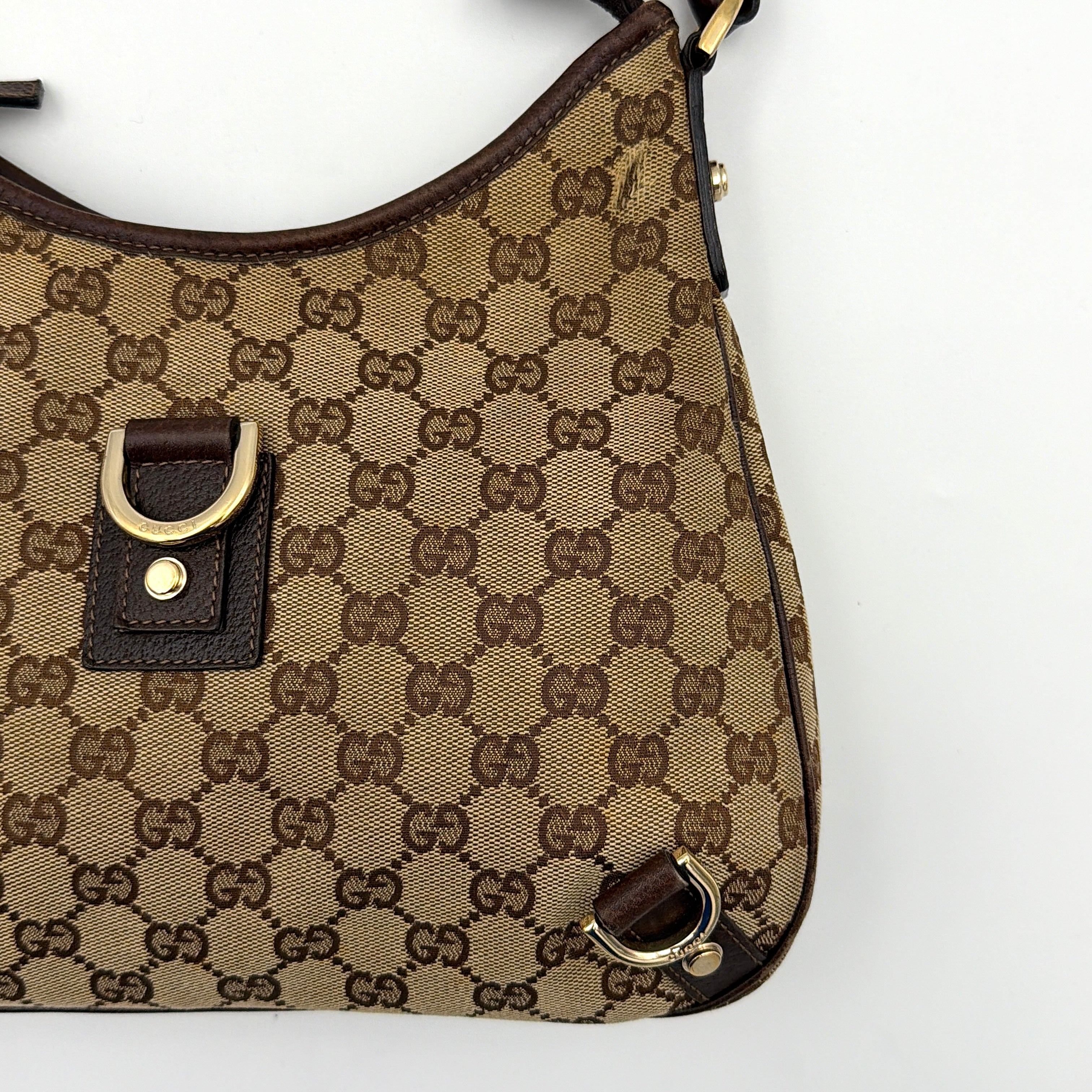 Front view of the Gucci GG Monogram Jacquard Abbey Hobo Bag in beige and brown canvas with gold-tone hardware and dark brown leather trim.