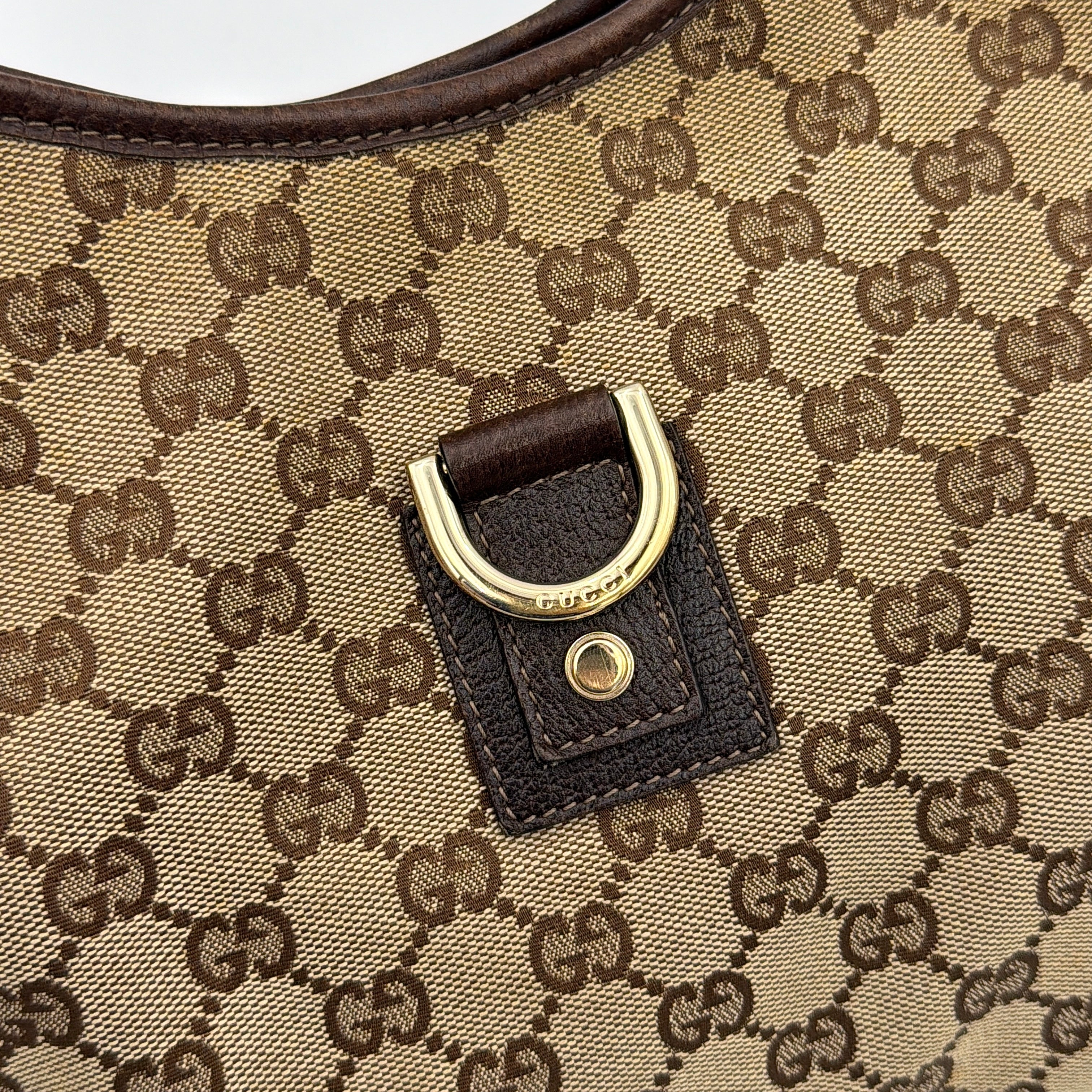 Front view of the Gucci GG Monogram Jacquard Abbey Hobo Bag in beige and brown canvas with gold-tone hardware and dark brown leather trim.