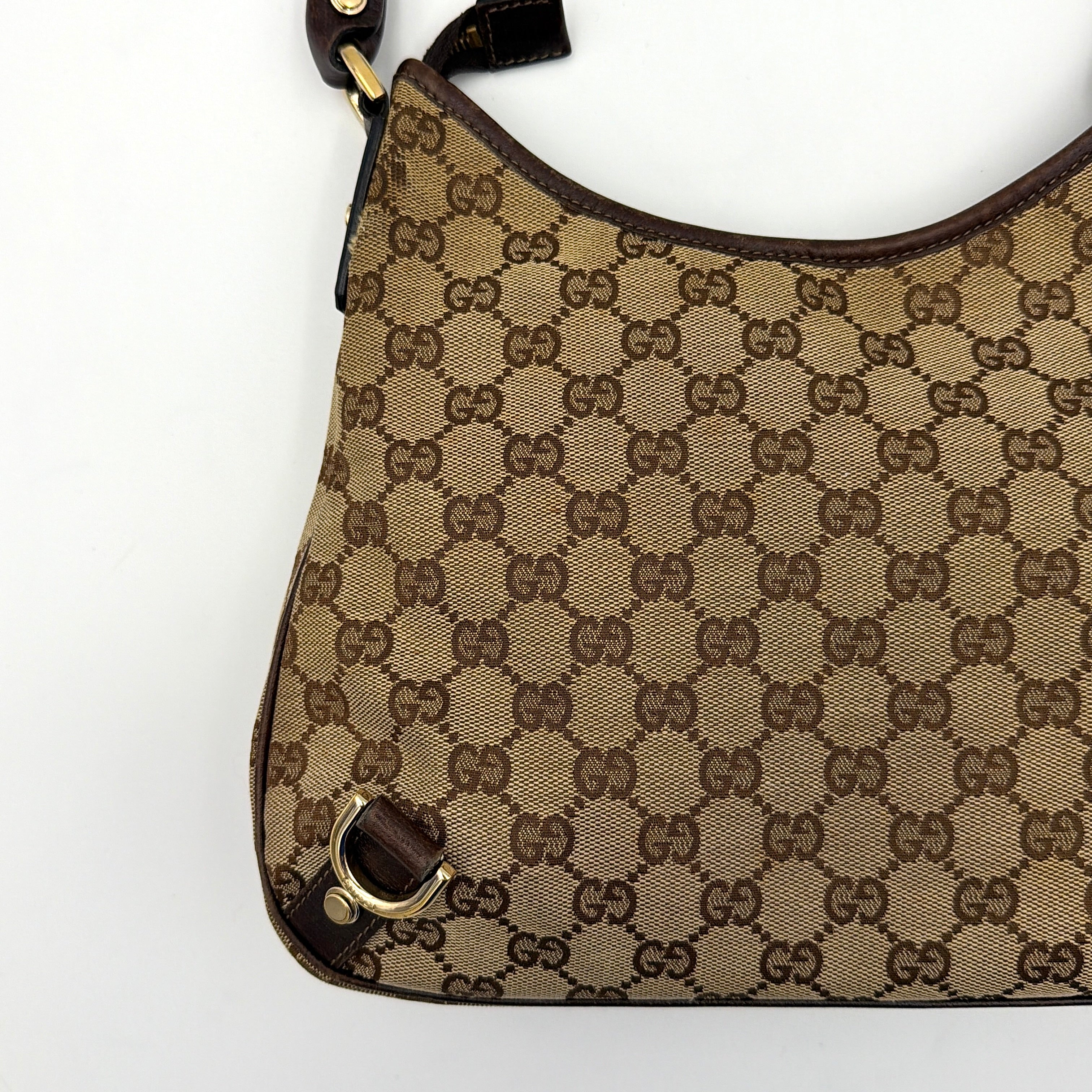 Front view of the Gucci GG Monogram Jacquard Abbey Hobo Bag in beige and brown canvas with gold-tone hardware and dark brown leather trim.