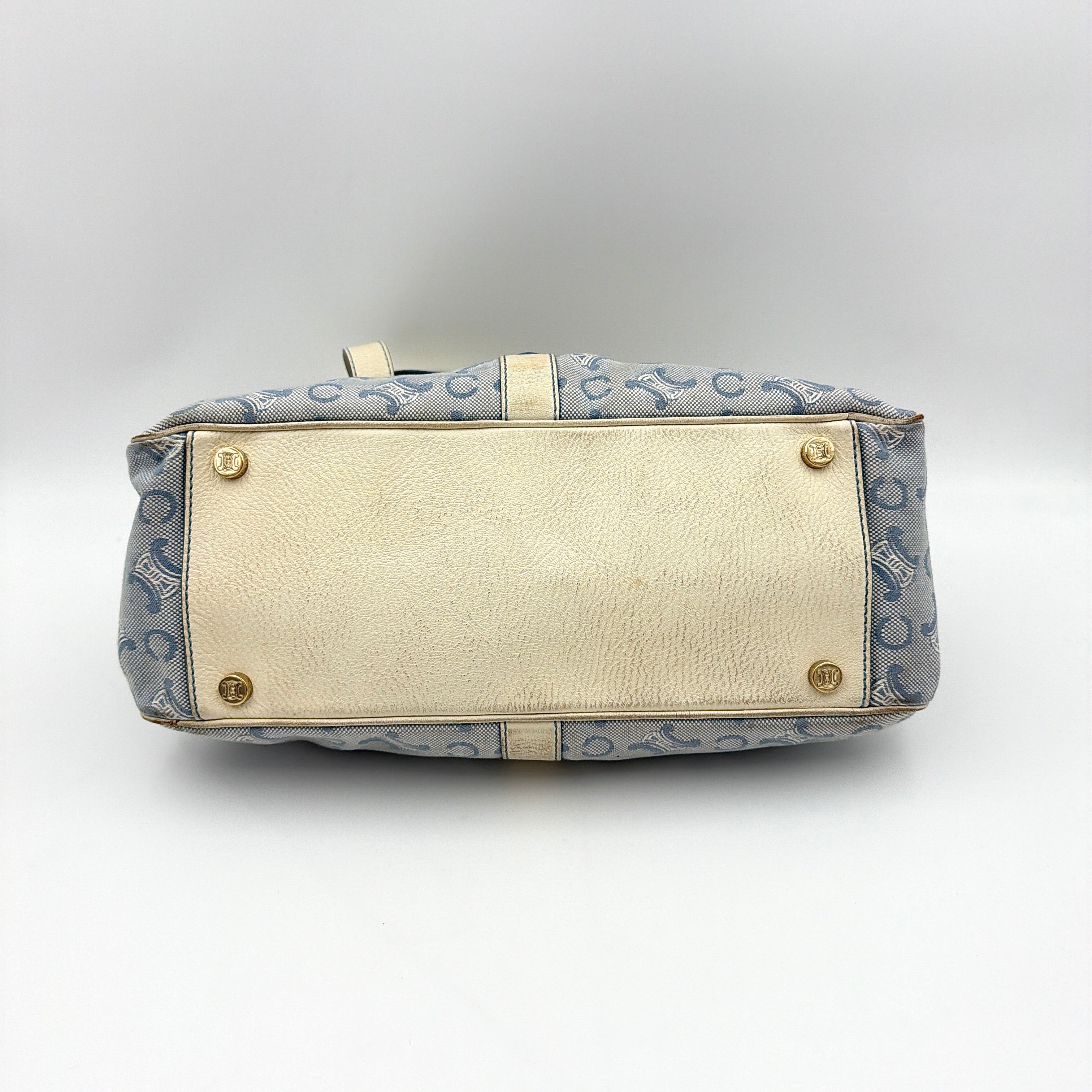 Front view of the Celine Macadam Canvas Shoulder Bag in blue canvas and cream leather with braided handles and gold hardware.