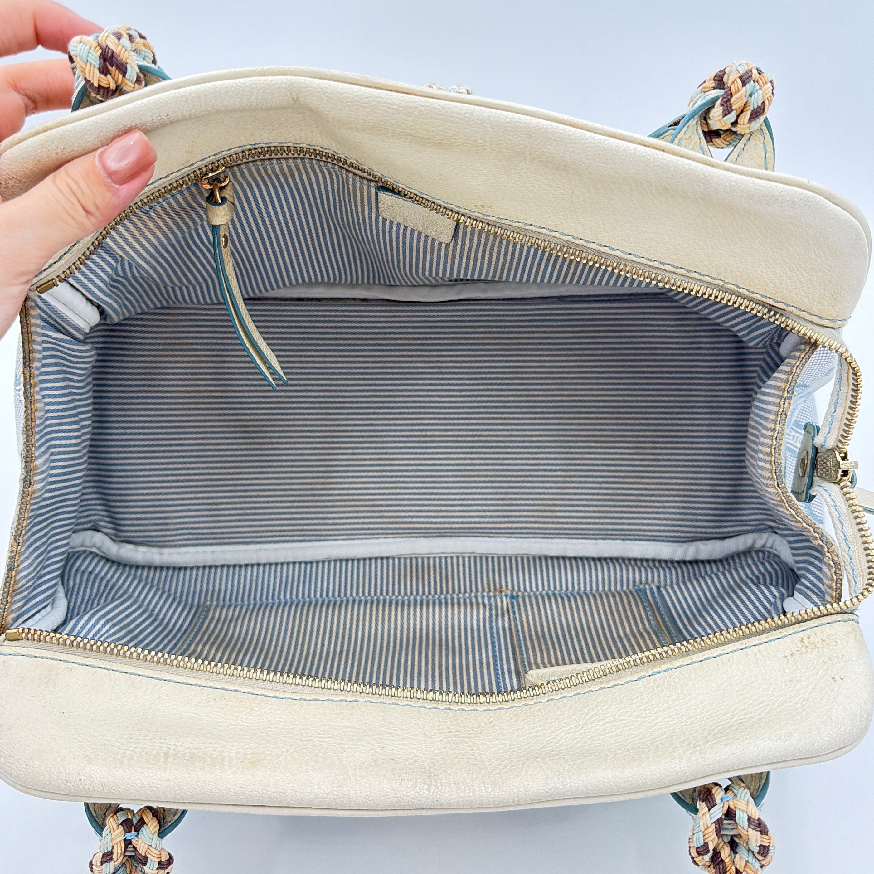 Front view of the Celine Macadam Canvas Shoulder Bag in blue canvas and cream leather with braided handles and gold hardware.