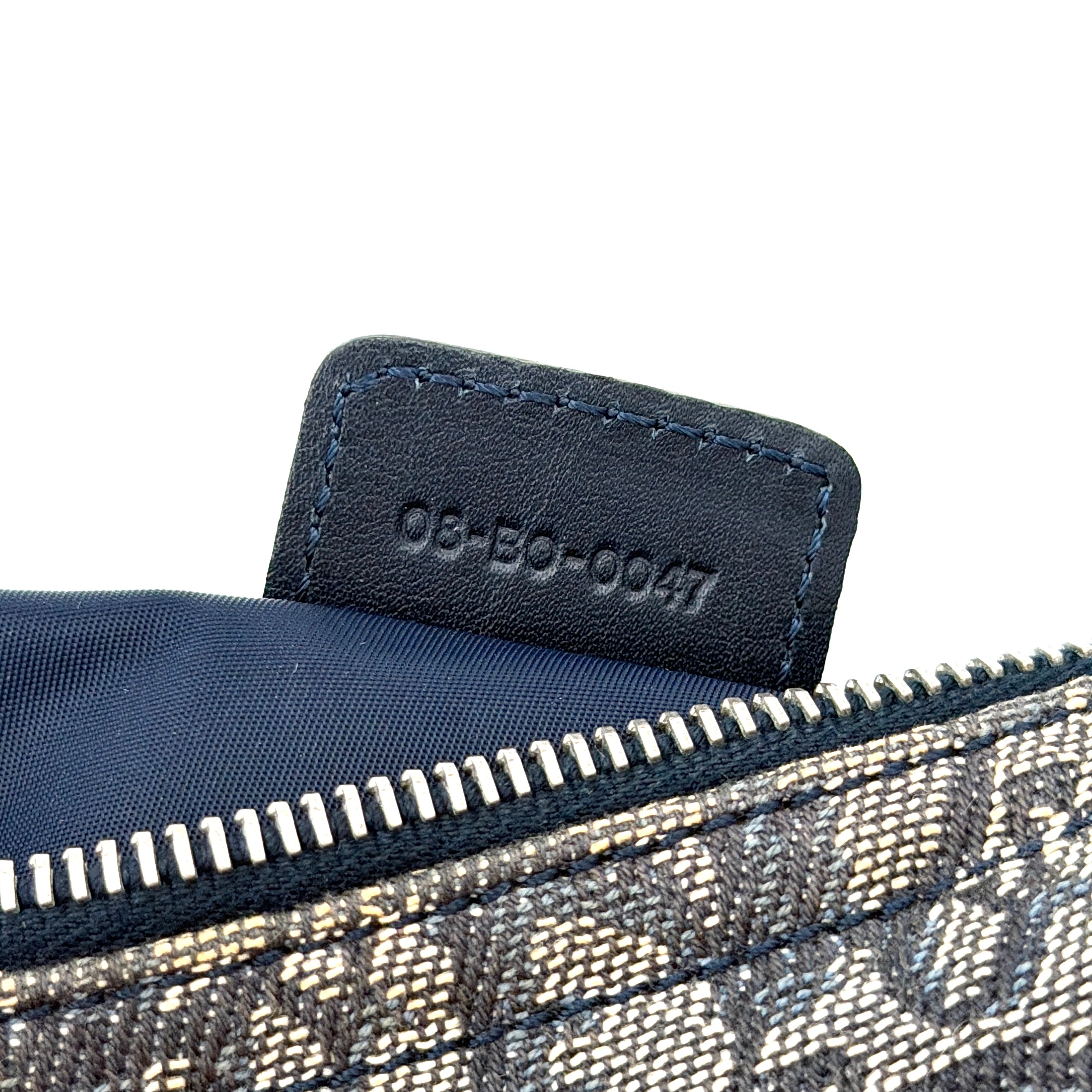 Dior Trotter Charm Pochette bag in grey and navy oblique canvas, featuring bold silver-tone Dior letter charms and a black leather strap.