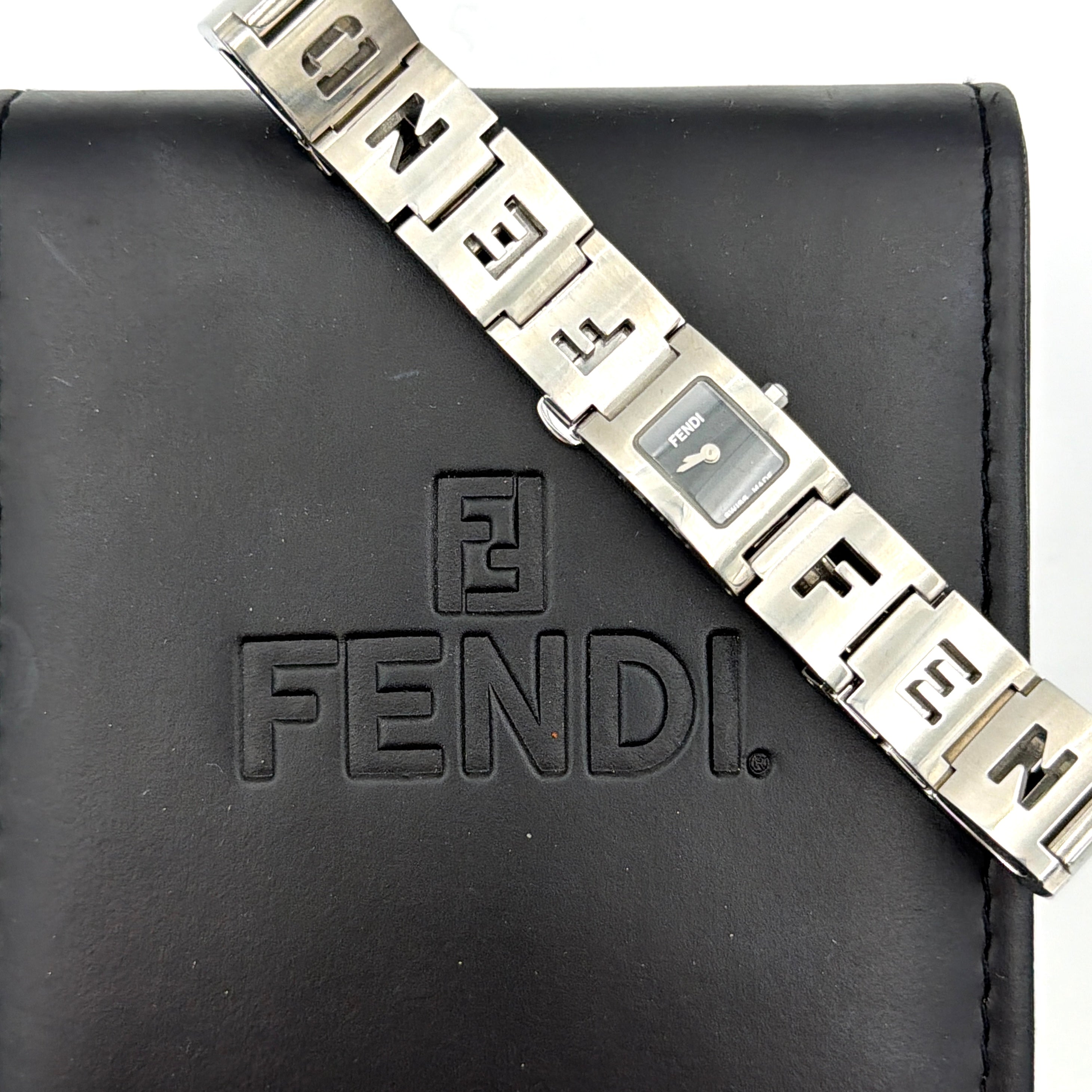 Fendi 3150L FF Logo Belt Watch in silver with a black dial, presented in a black Fendi box with gold logo accents.