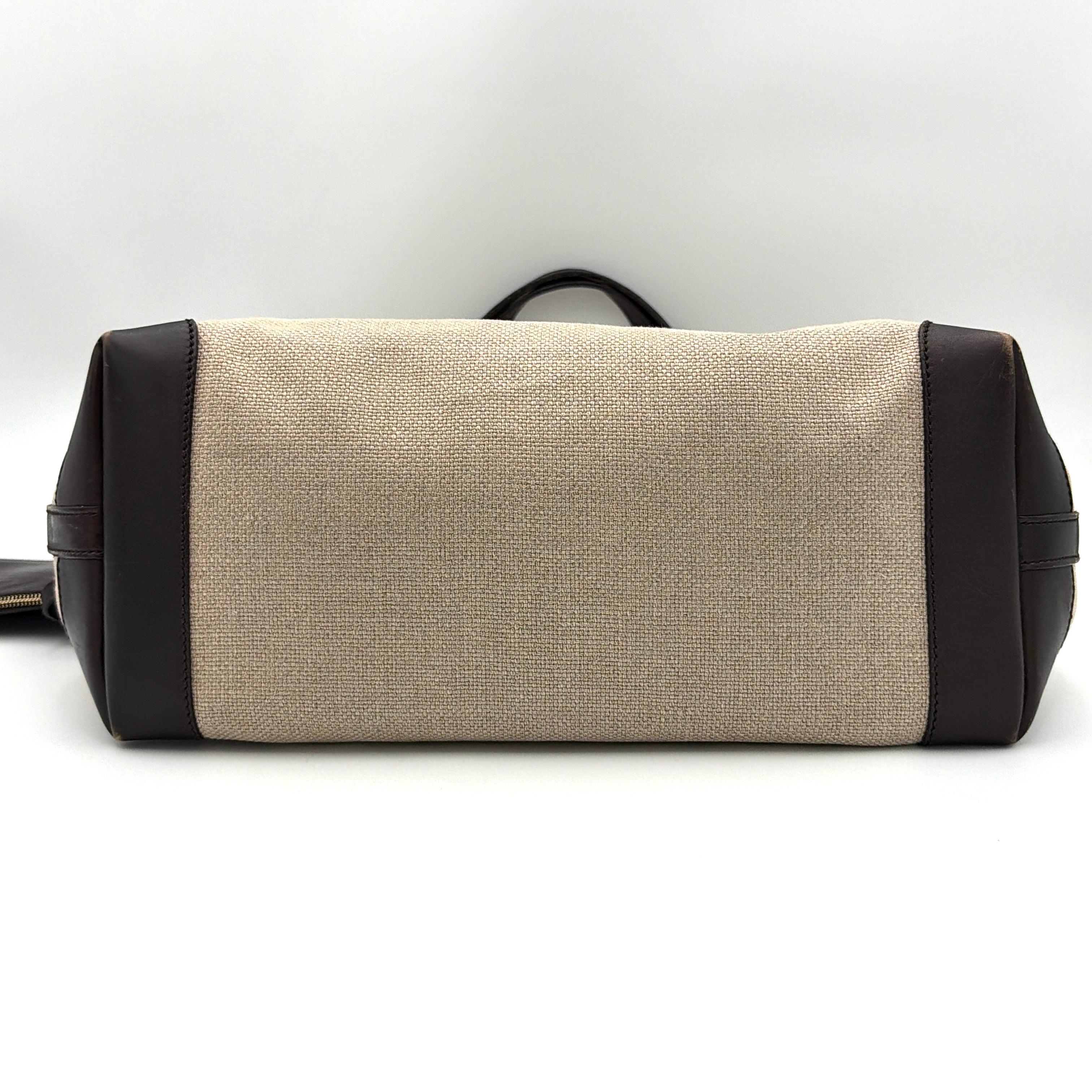 Gucci beige canvas shoulder bag with brown leather trim, bold Gucci logo, and matching detachable leather pouch.