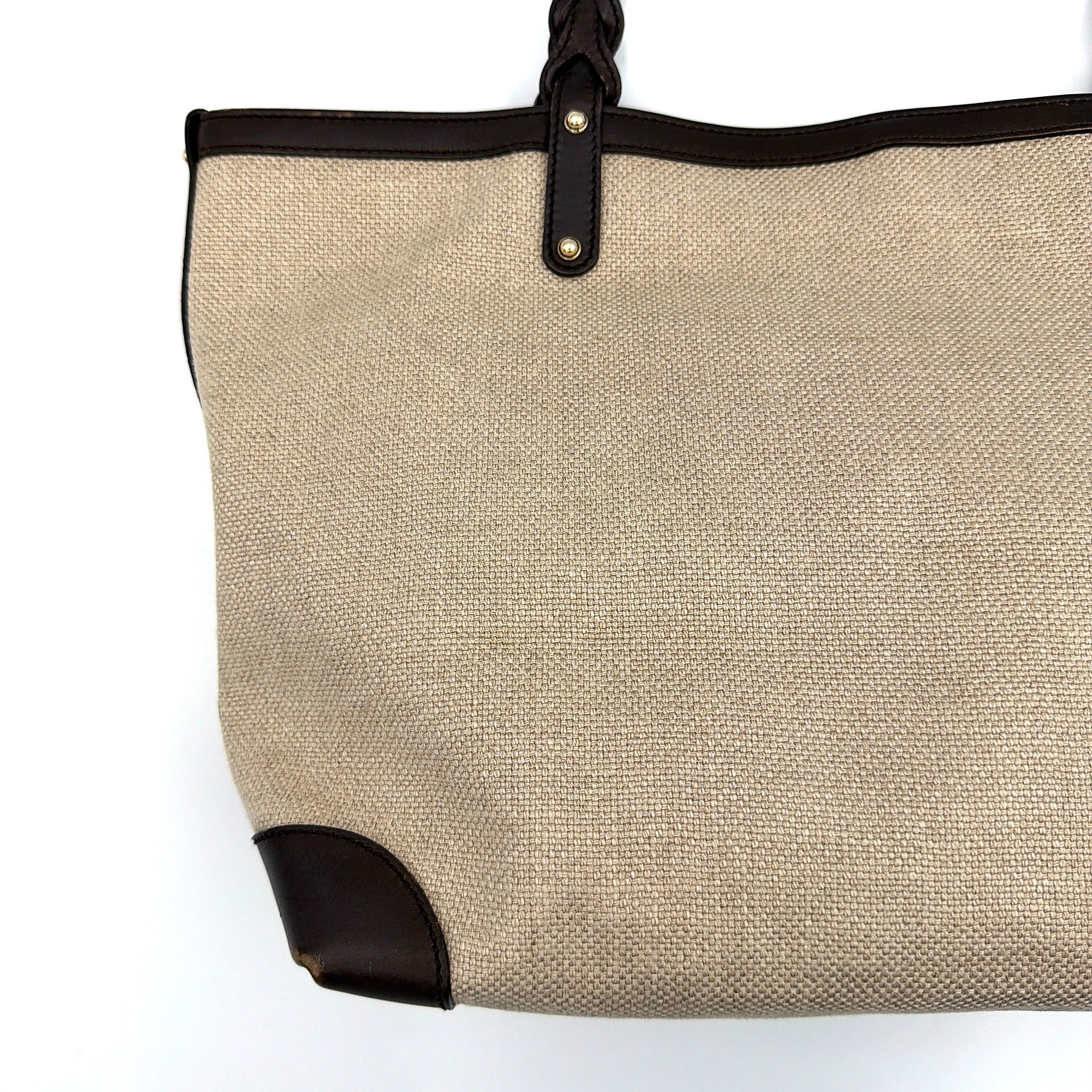 Gucci beige canvas shoulder bag with brown leather trim, bold Gucci logo, and matching detachable leather pouch.
