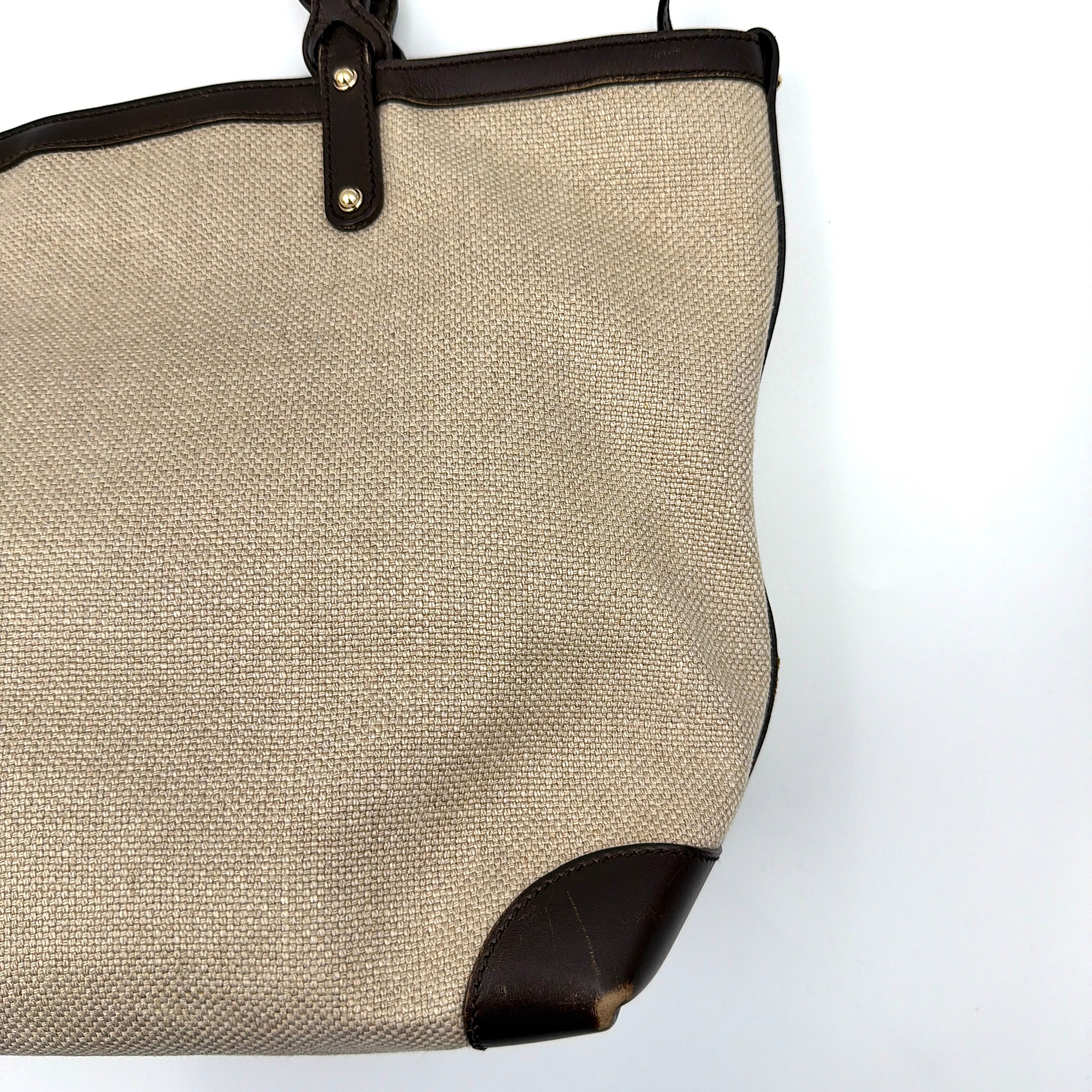 Gucci beige canvas shoulder bag with brown leather trim, bold Gucci logo, and matching detachable leather pouch.