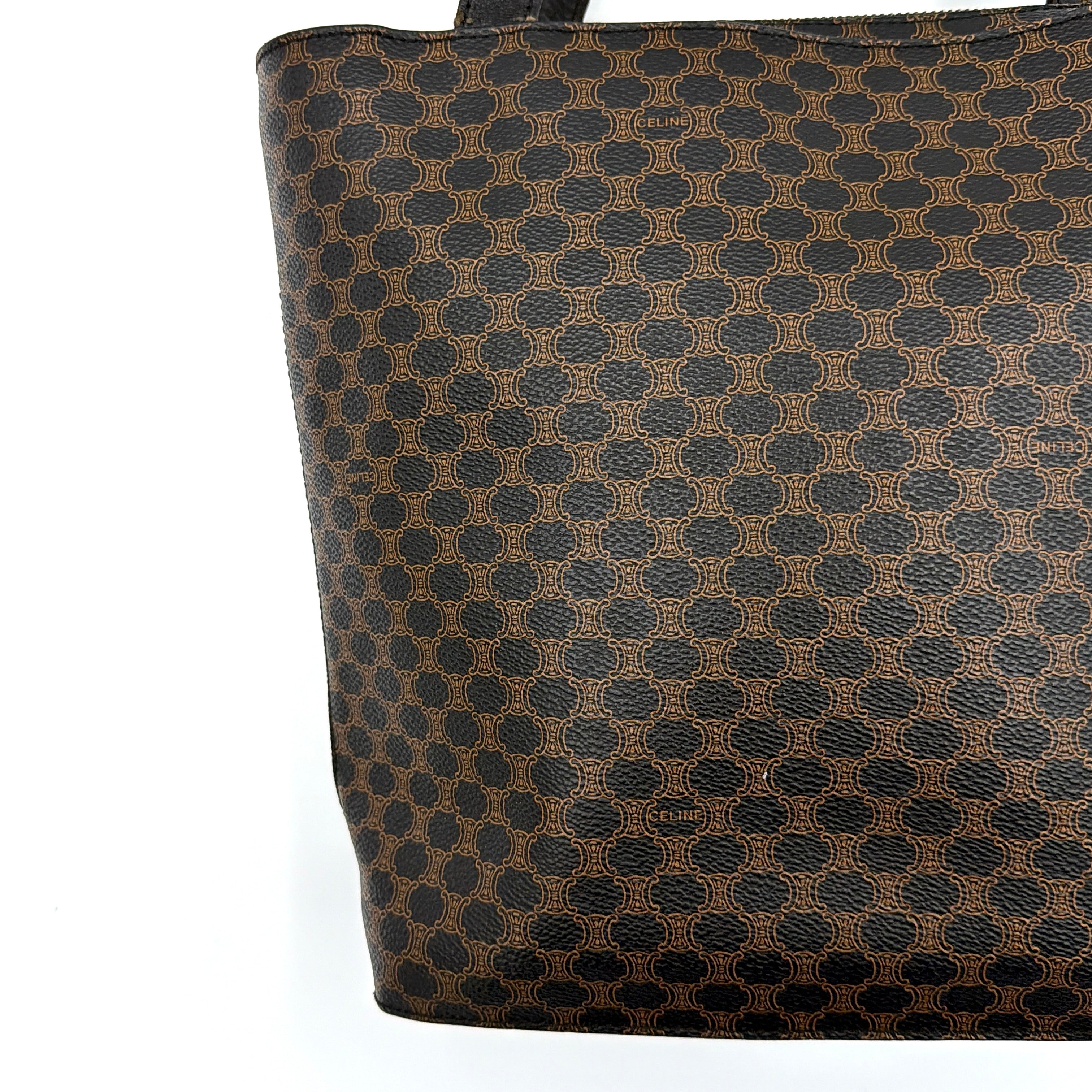 Celine Macadam Blason Tote Bag in brown coated canvas with all-over Macadam motif, black leather trim, and gold-tone Blason emblem front pocket.