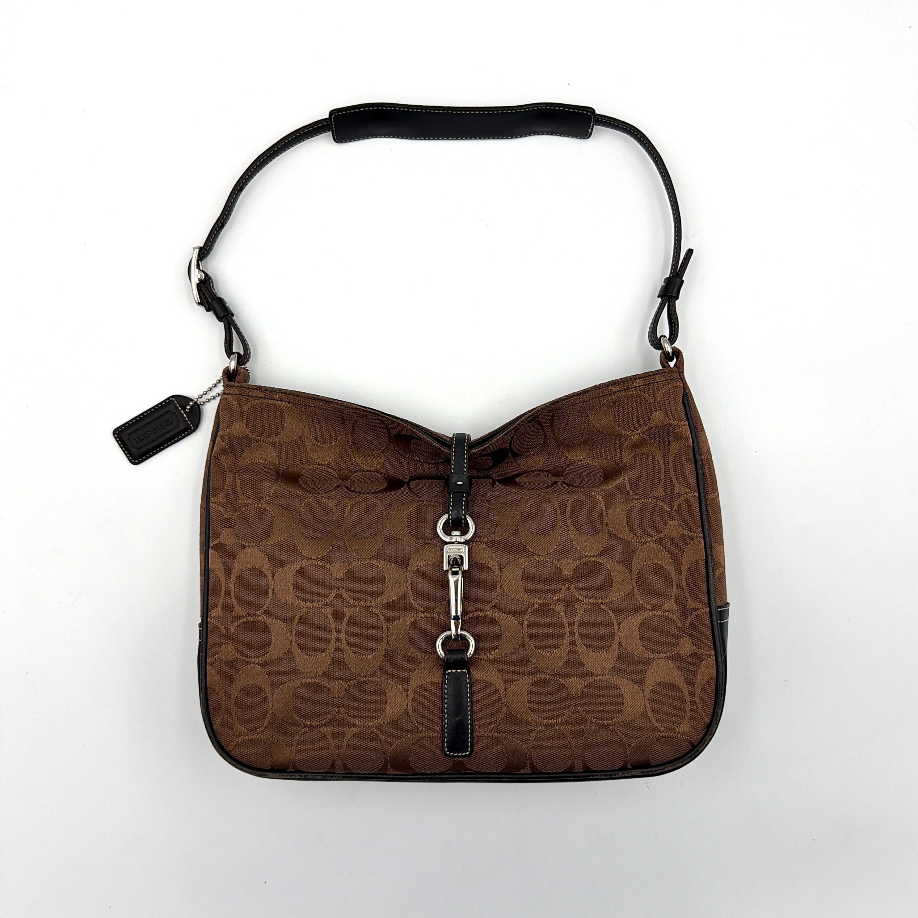Coach Hobo Signature Clip canvas handbag in brown with black leather trim and silver hardware displayed against a plain background.