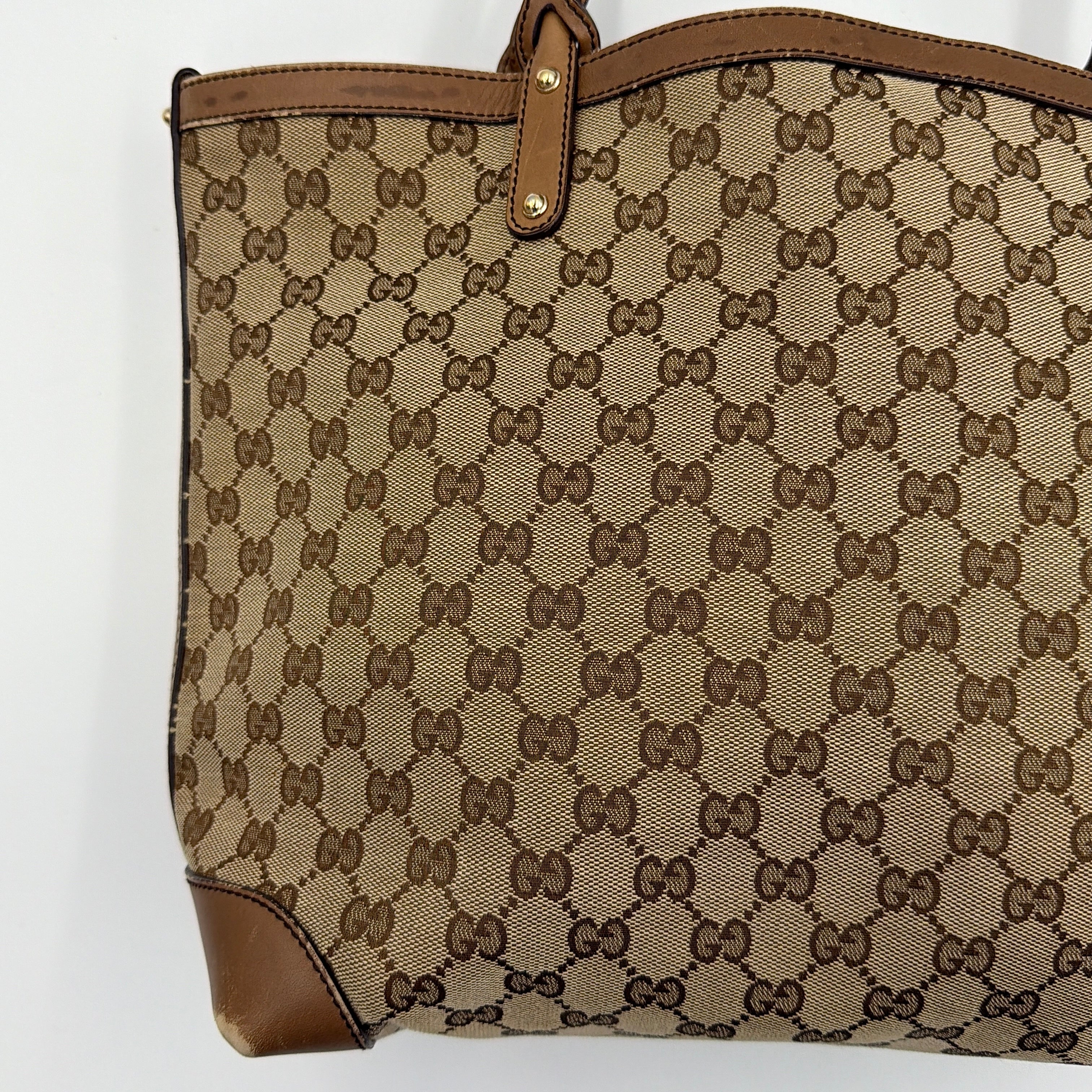 Gucci GG Monogram Craft Shoulder Bag in beige and brown canvas with double leather straps and matching logo-embossed leather pouch.