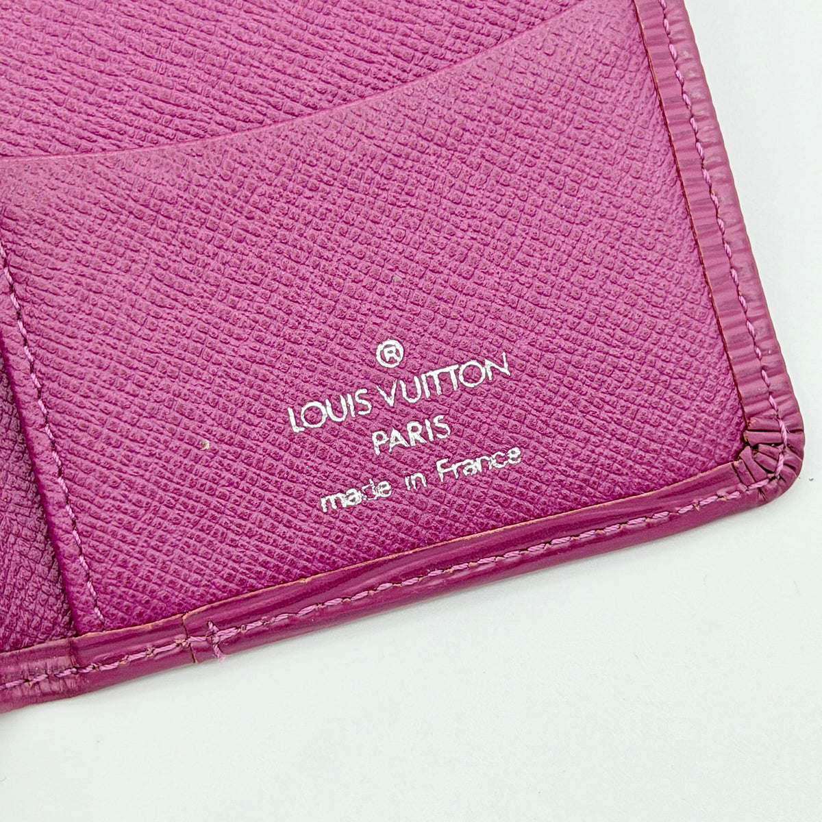 Louis Vuitton Epi Pocket Organizer in vivid pink leather, shown with distinctive LV embossing and textured finish.