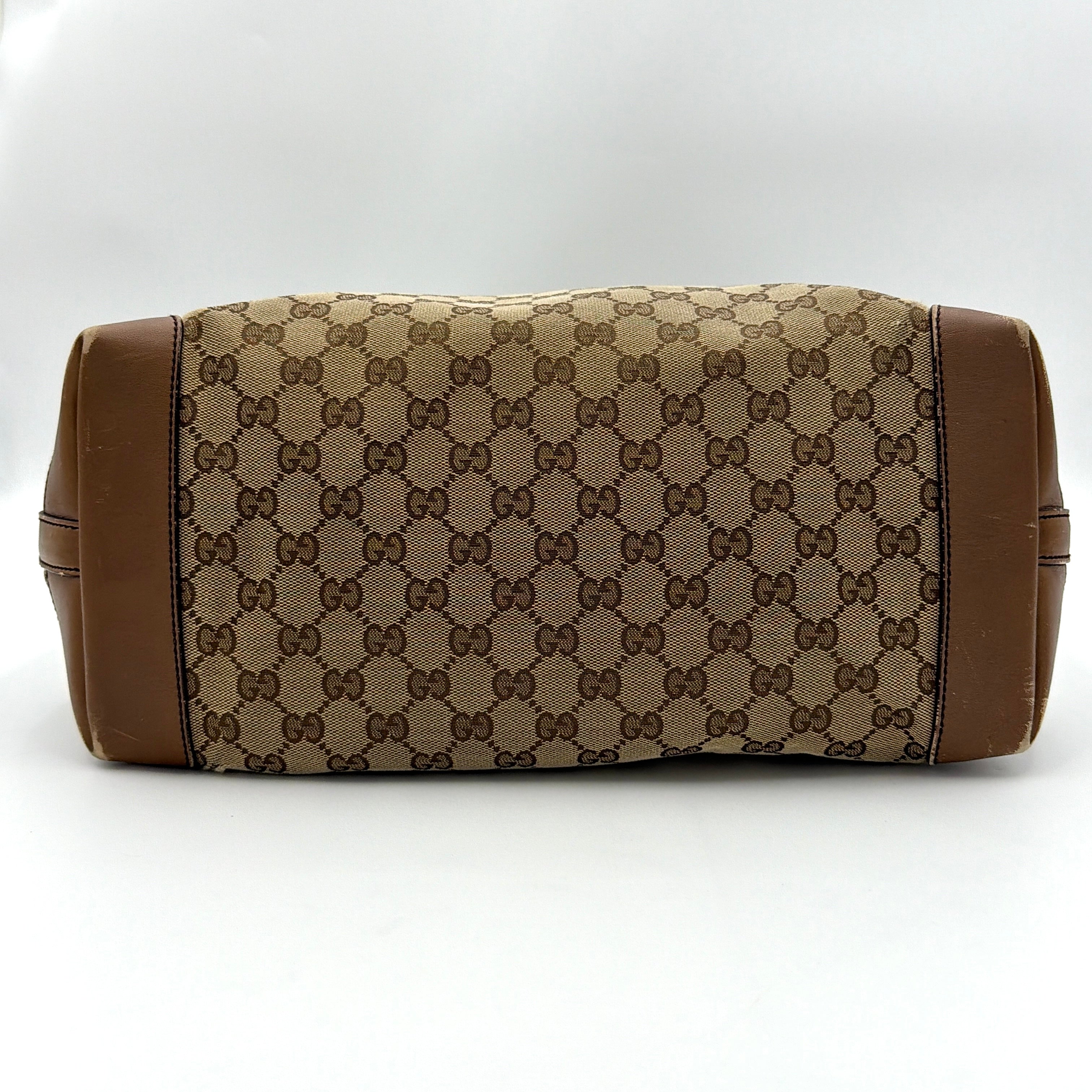 Gucci GG Monogram Craft Shoulder Bag in beige and brown canvas with double leather straps and matching logo-embossed leather pouch.
