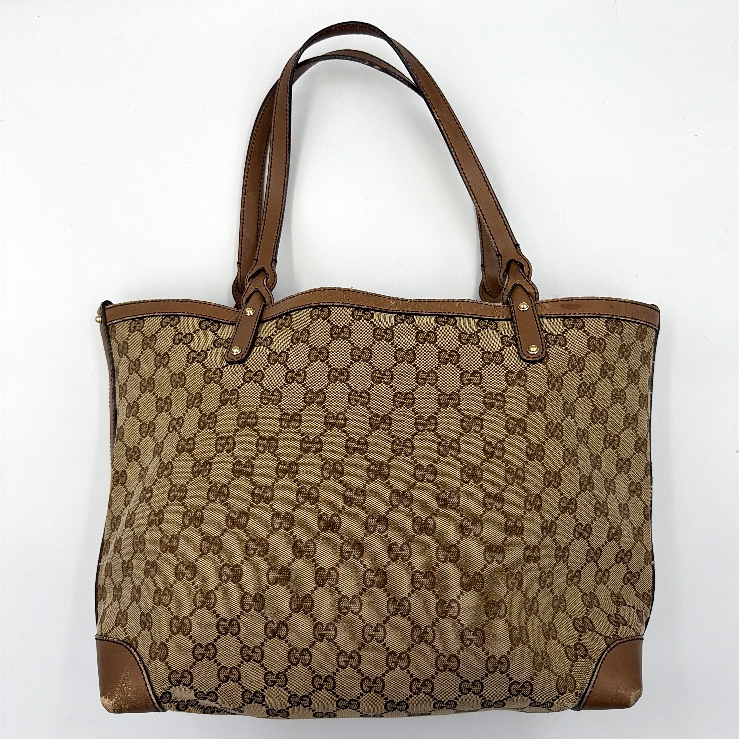 Gucci GG Monogram Craft Shoulder Bag in beige and brown canvas with double leather straps and matching logo-embossed leather pouch.