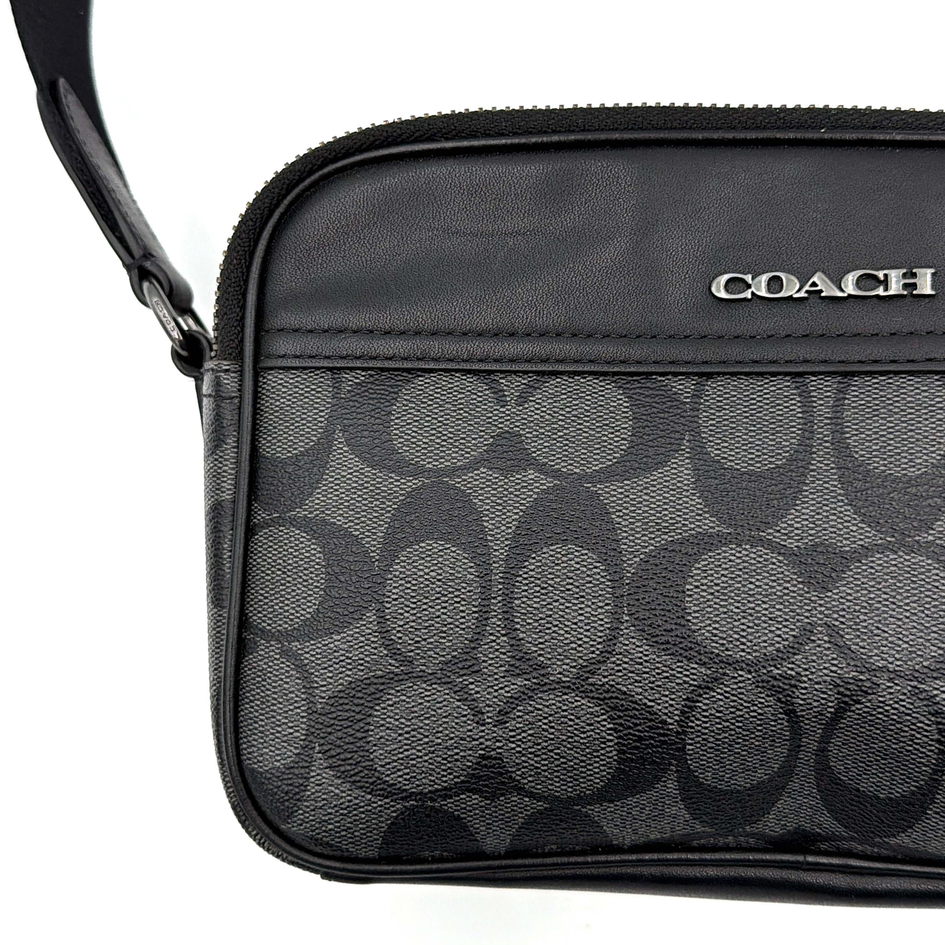 Coach Signature Graham Crossbody Bag in grey and black with adjustable web strap and silver-tone hardware, presented against a white background.