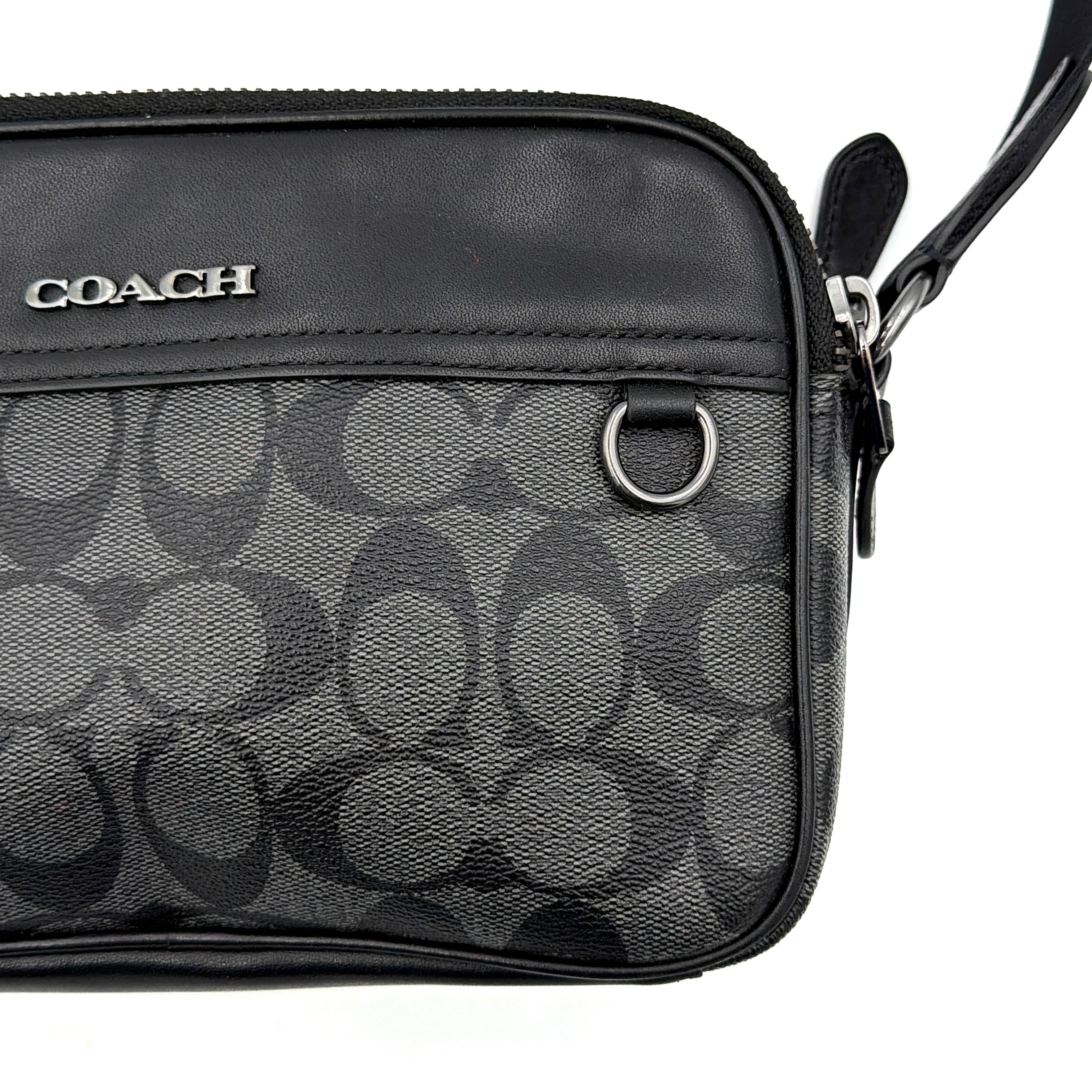 Coach Signature Graham Crossbody Bag in grey and black with adjustable web strap and silver-tone hardware, presented against a white background.