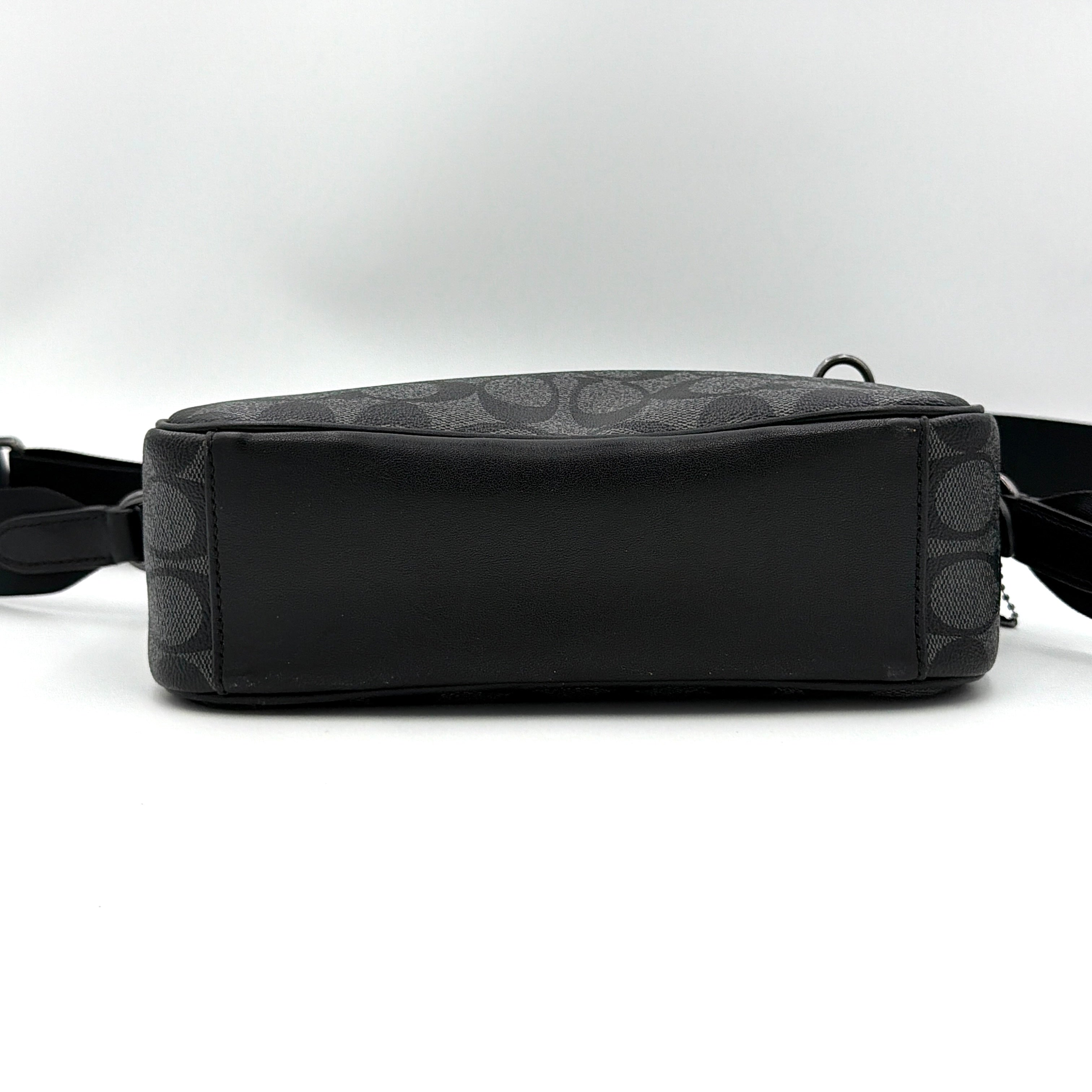 Coach Signature Graham Crossbody Bag in grey and black with adjustable web strap and silver-tone hardware, presented against a white background.