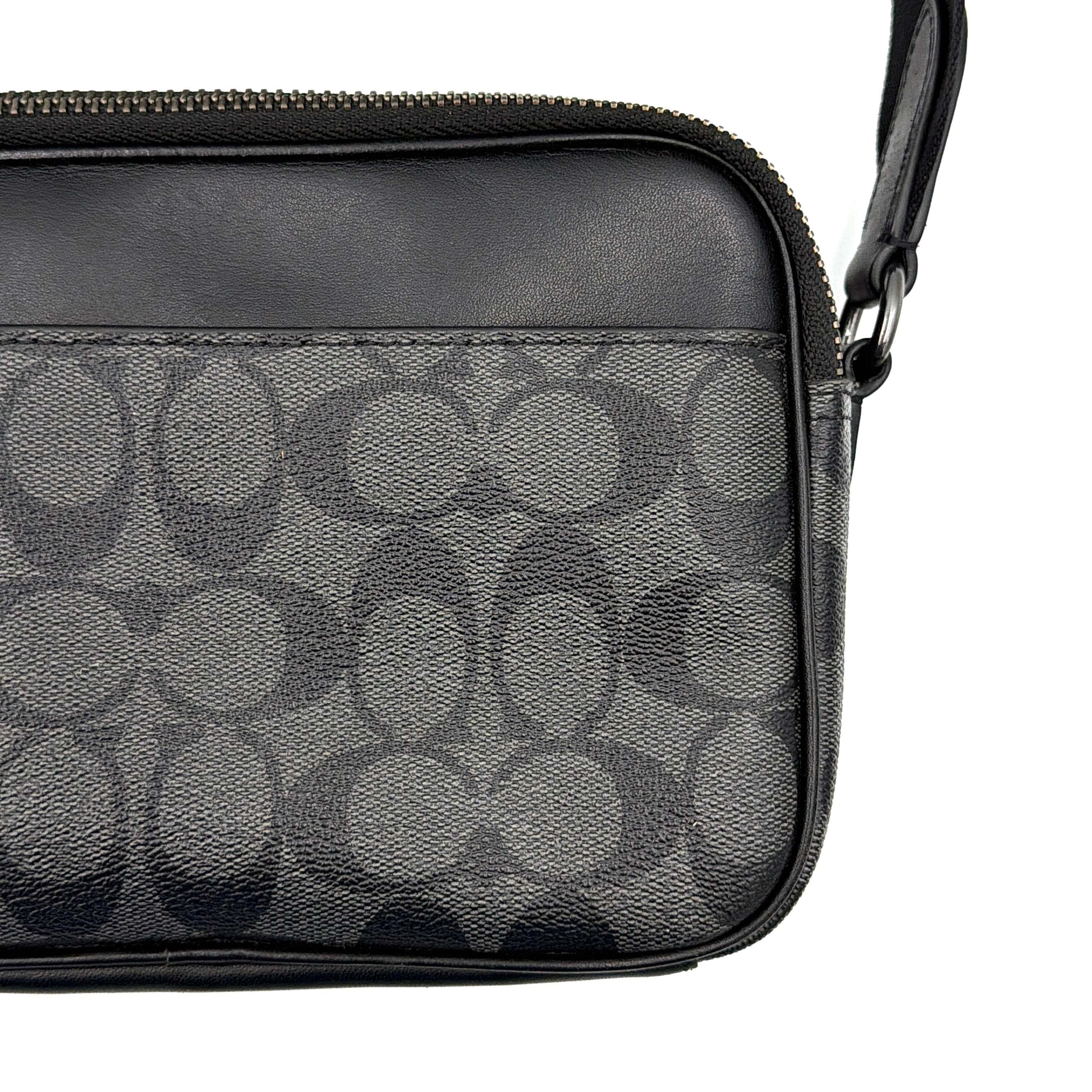 Coach Signature Graham Crossbody Bag in grey and black with adjustable web strap and silver-tone hardware, presented against a white background.