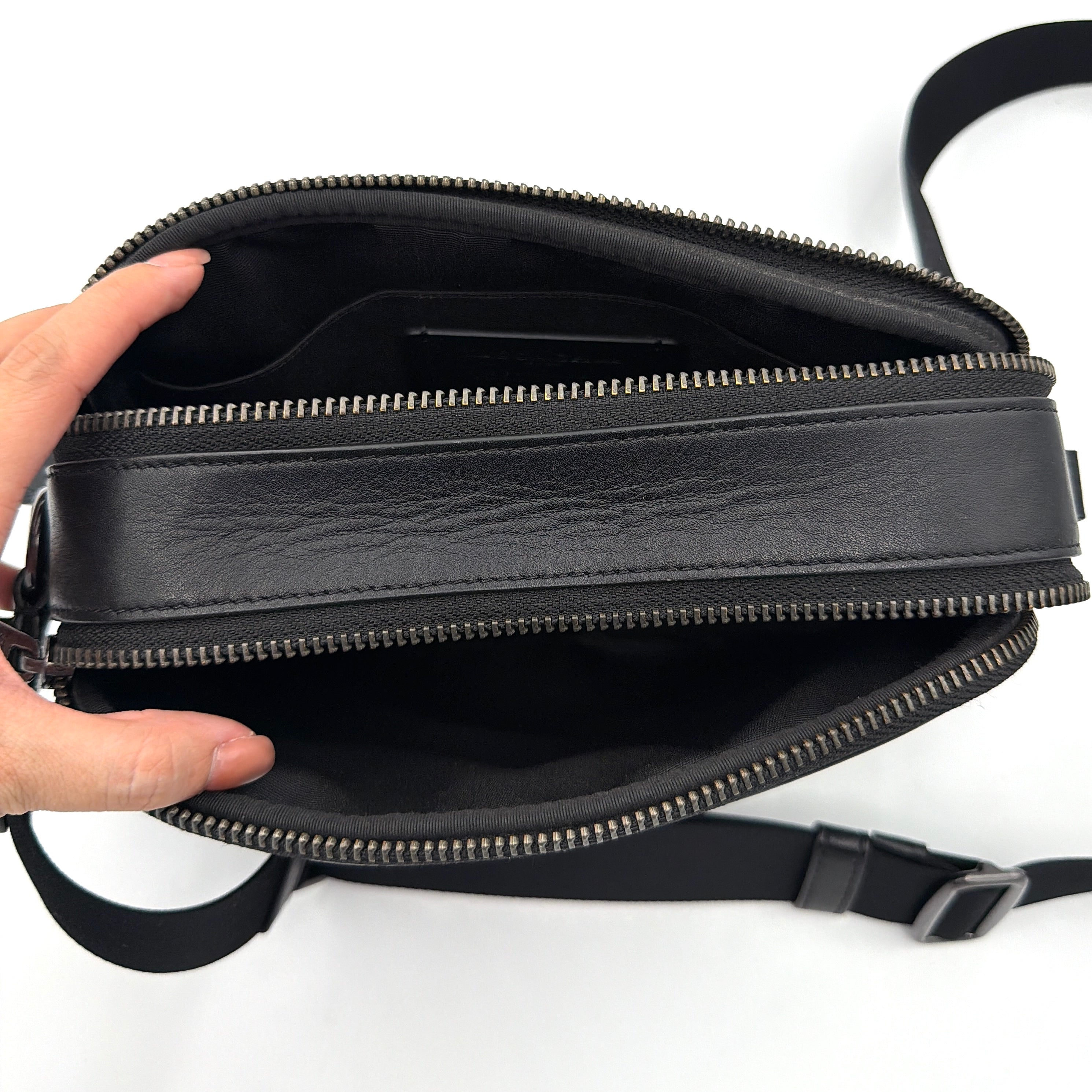 Coach Signature Graham Crossbody Bag in grey and black with adjustable web strap and silver-tone hardware, presented against a white background.