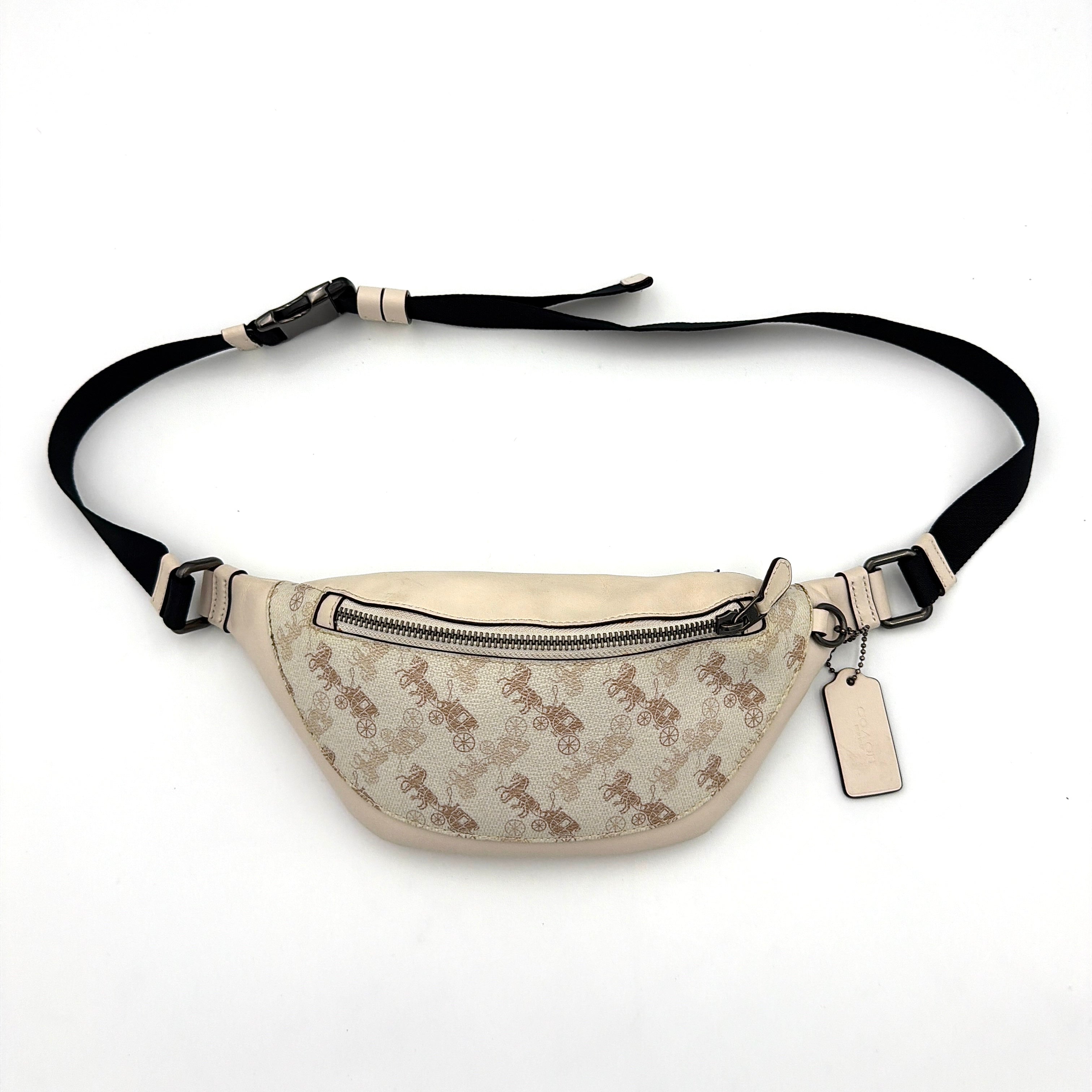 Coach Mini Warren belt bag in cream canvas with tan horse and carriage motif, leather trim, and black adjustable strap.