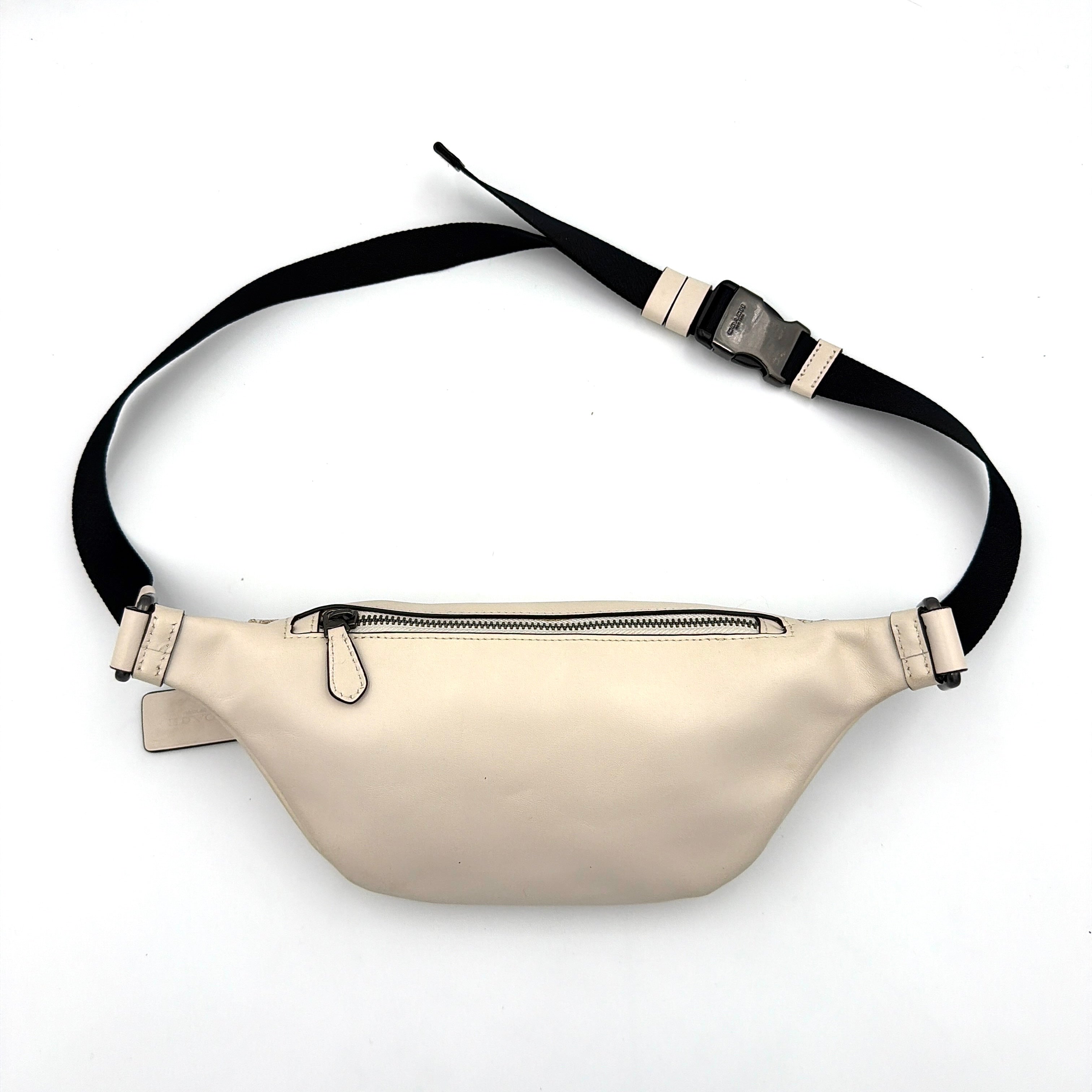 Coach Mini Warren belt bag in cream canvas with tan horse and carriage motif, leather trim, and black adjustable strap.