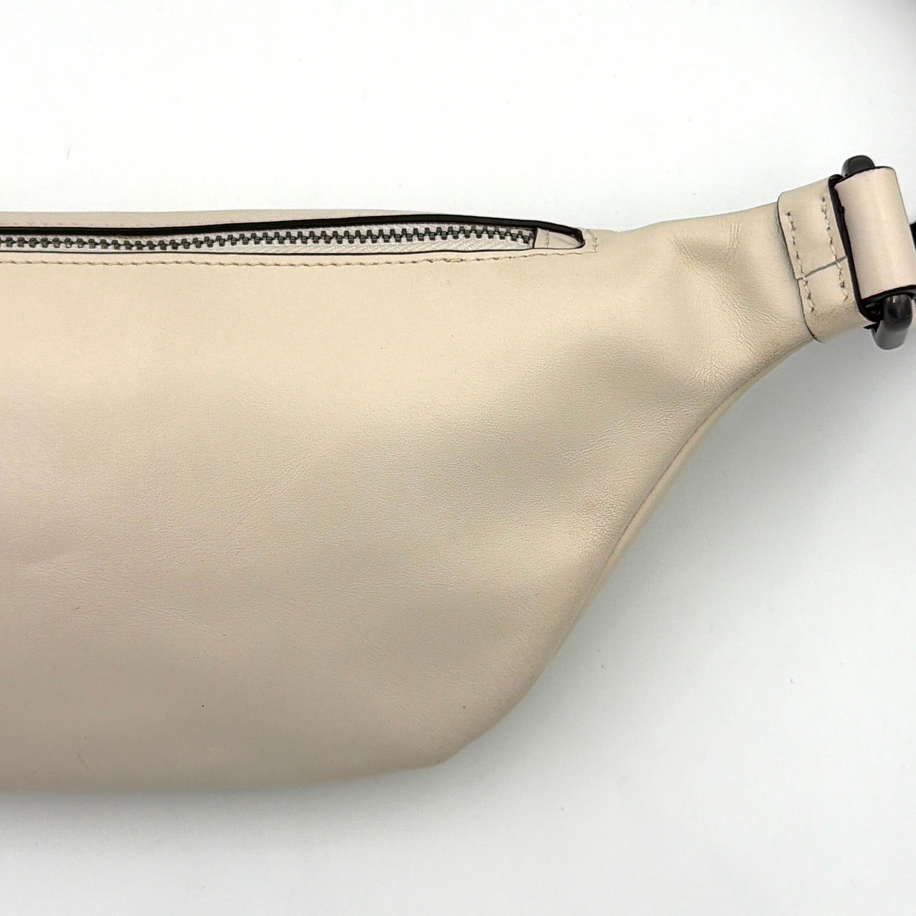 Coach Mini Warren belt bag in cream canvas with tan horse and carriage motif, leather trim, and black adjustable strap.