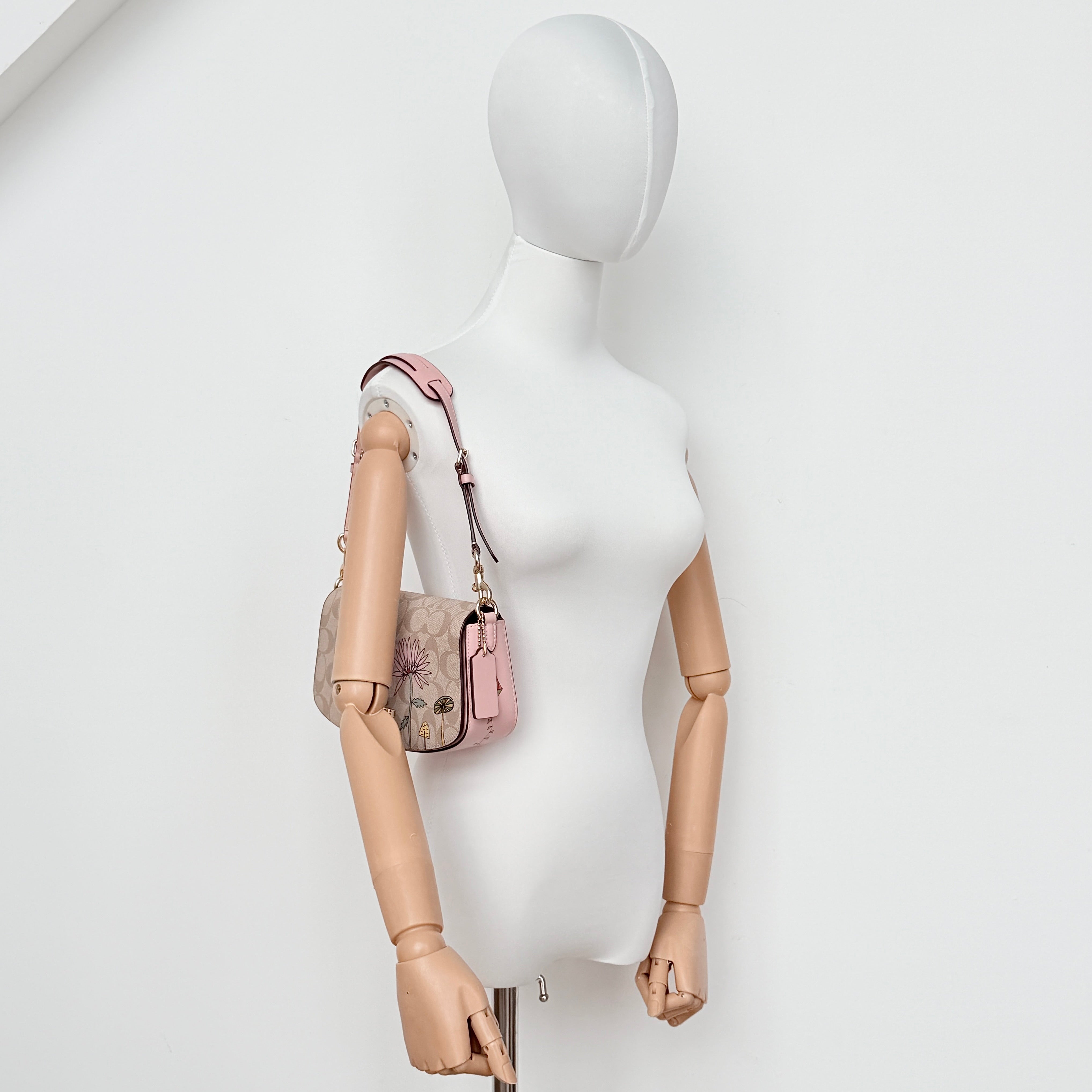 Coach X Observed By Us Andrea Shoulder Bag in beige monogram canvas with pink illustrations and pink leather strap.