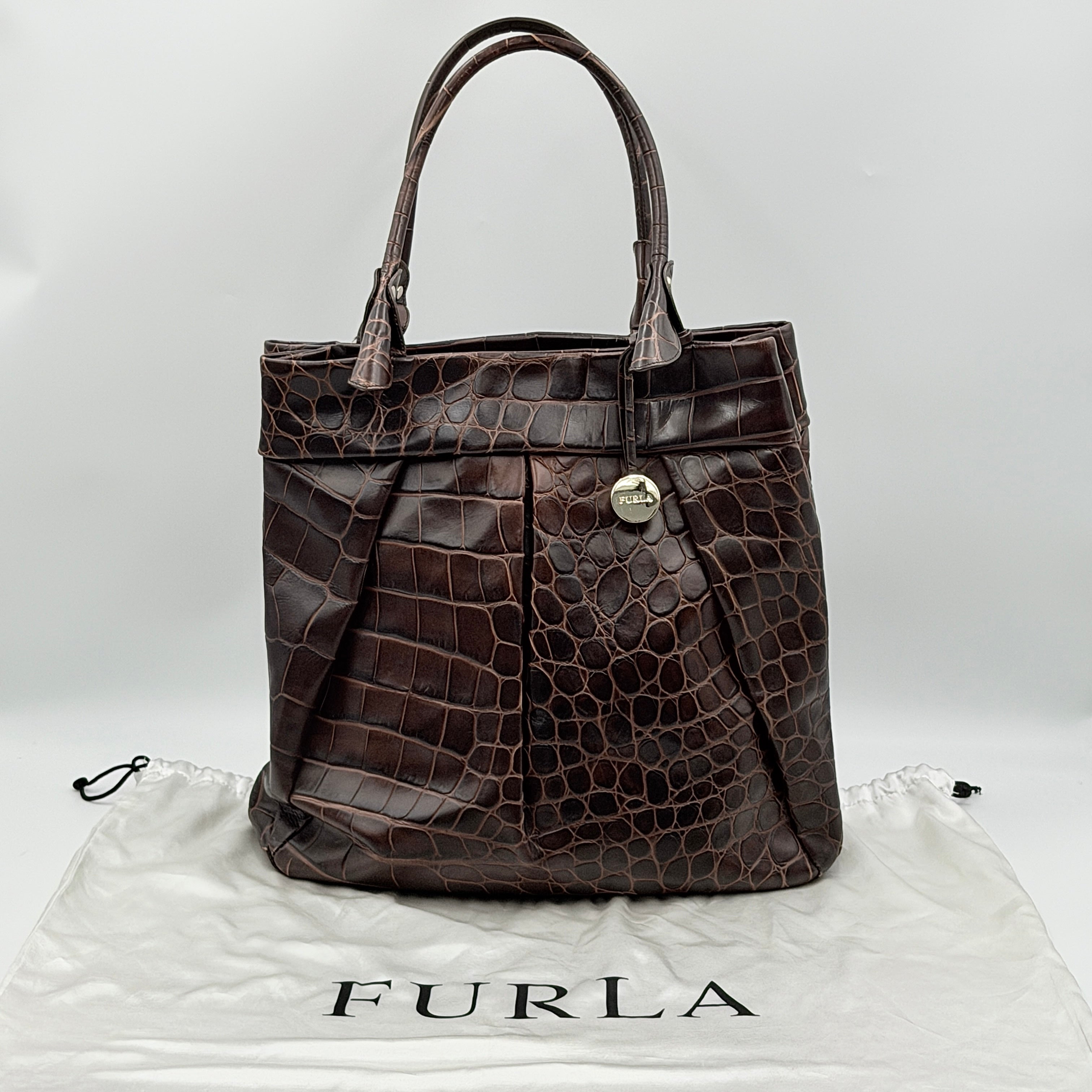 Furla dark brown croc-embossed leather tote bag with gold logo charm, structured silhouette, and double handles.