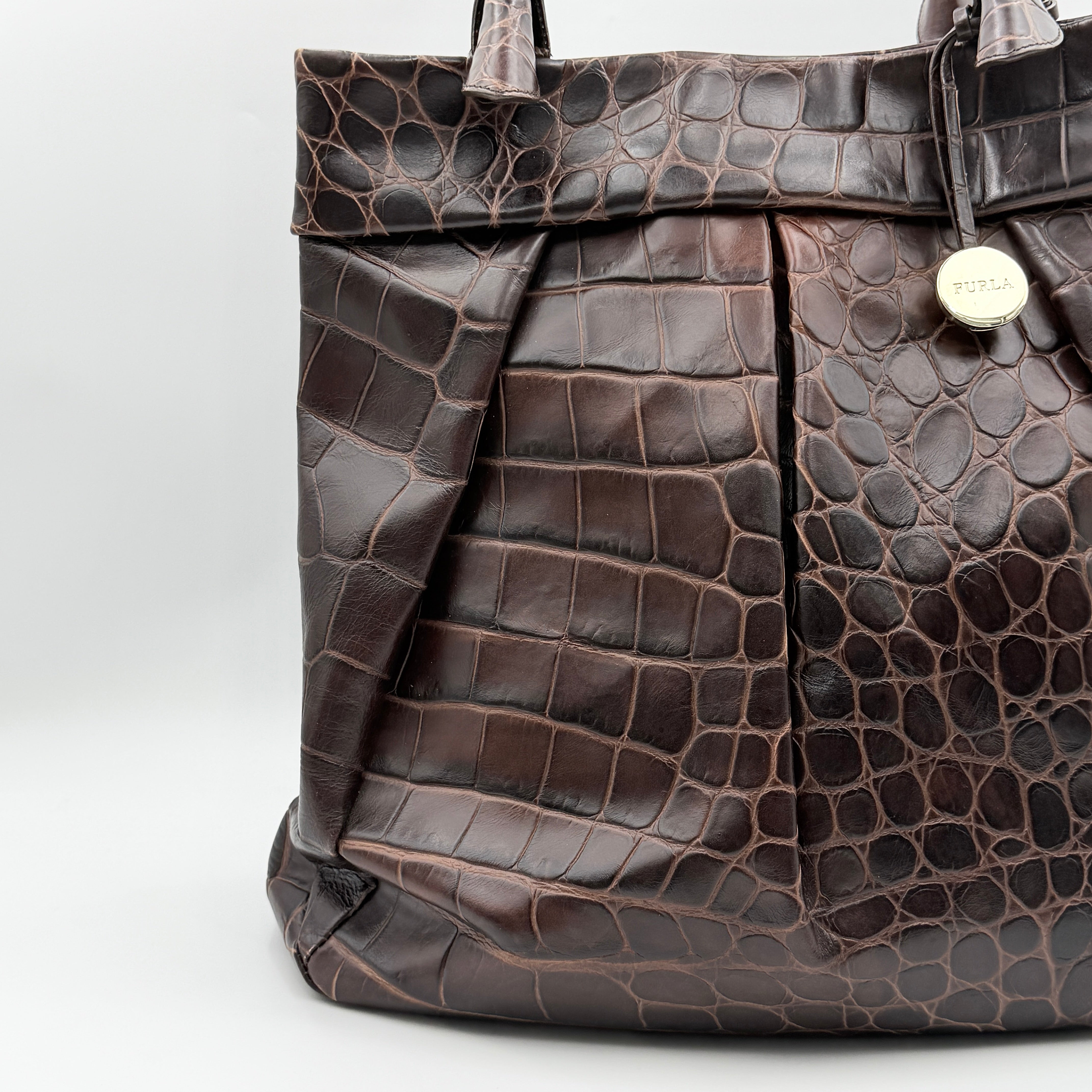 Furla dark brown croc-embossed leather tote bag with gold logo charm, structured silhouette, and double handles.