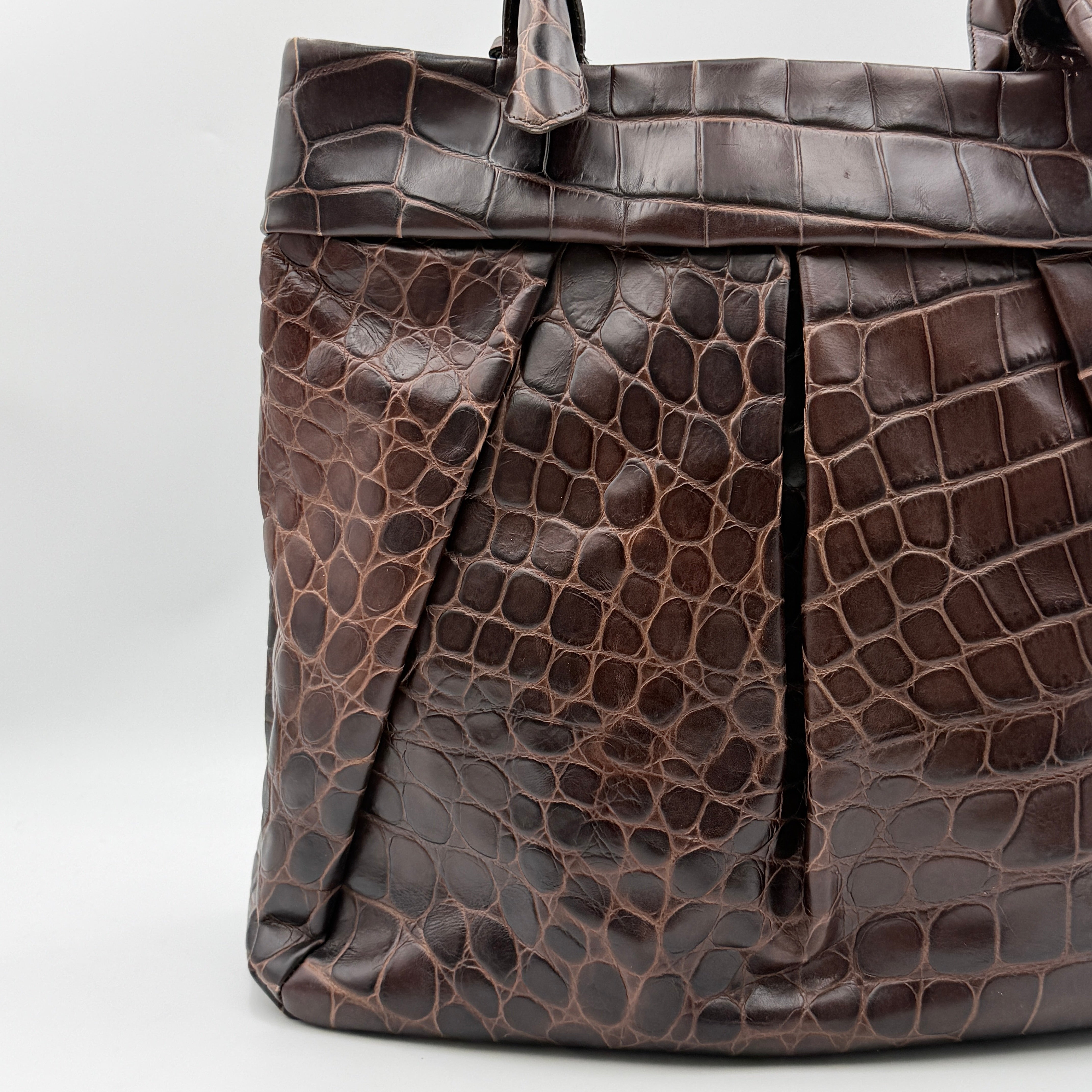 Furla dark brown croc-embossed leather tote bag with gold logo charm, structured silhouette, and double handles.