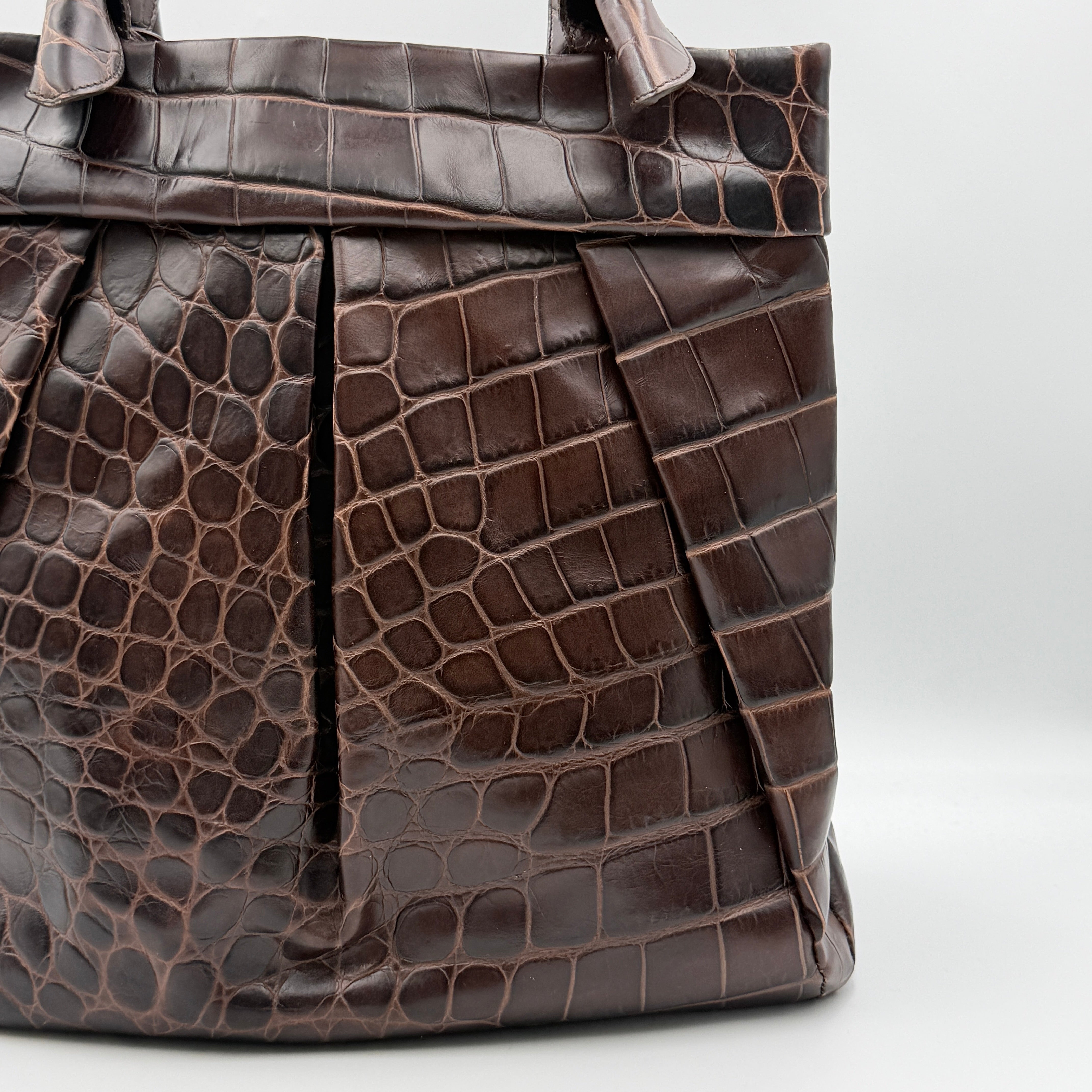 Furla dark brown croc-embossed leather tote bag with gold logo charm, structured silhouette, and double handles.