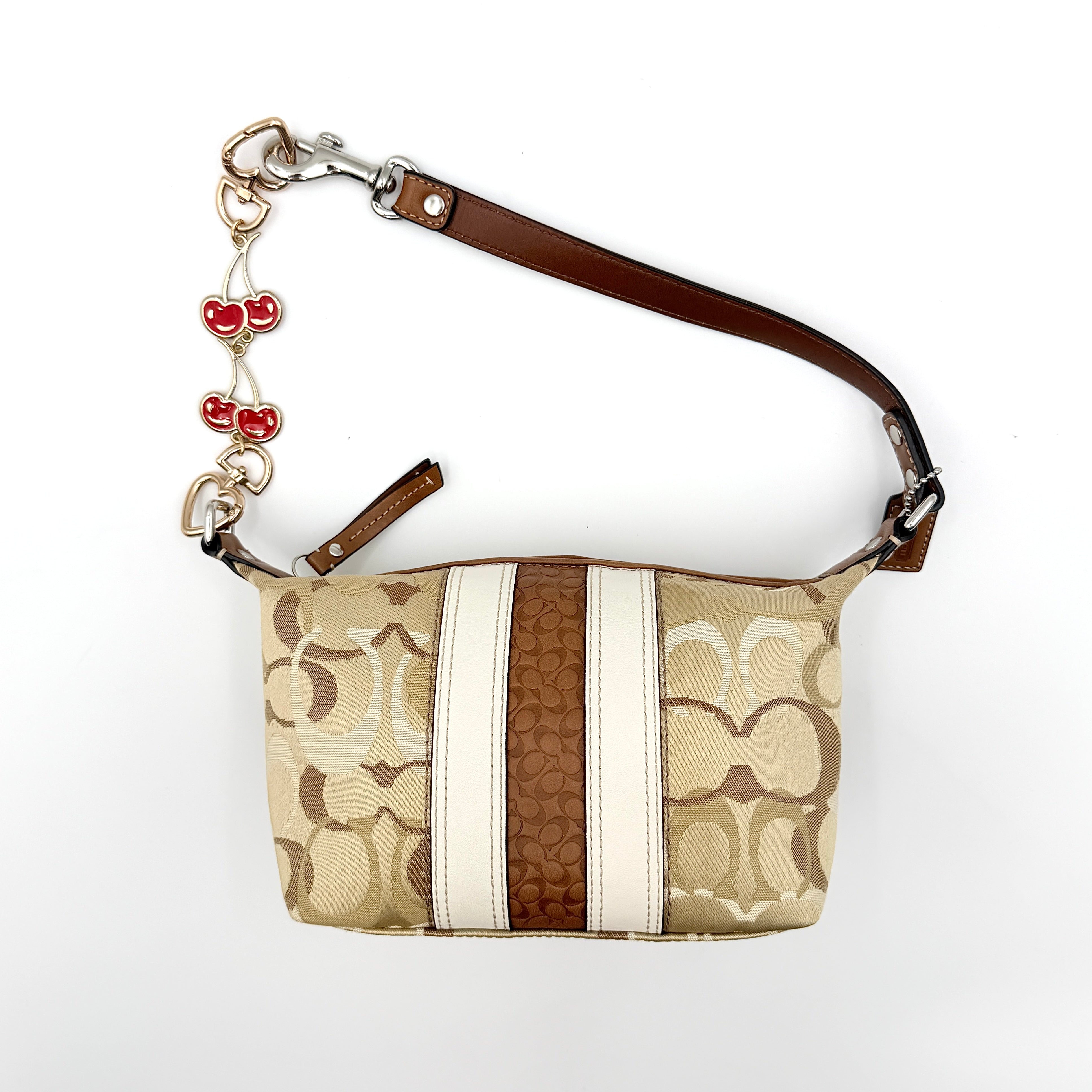 Coach Signature Stripe Mini Hobo Shoulder Bag in brown canvas with white and caramel stripes, featuring a brown leather strap and playful cherry charms.