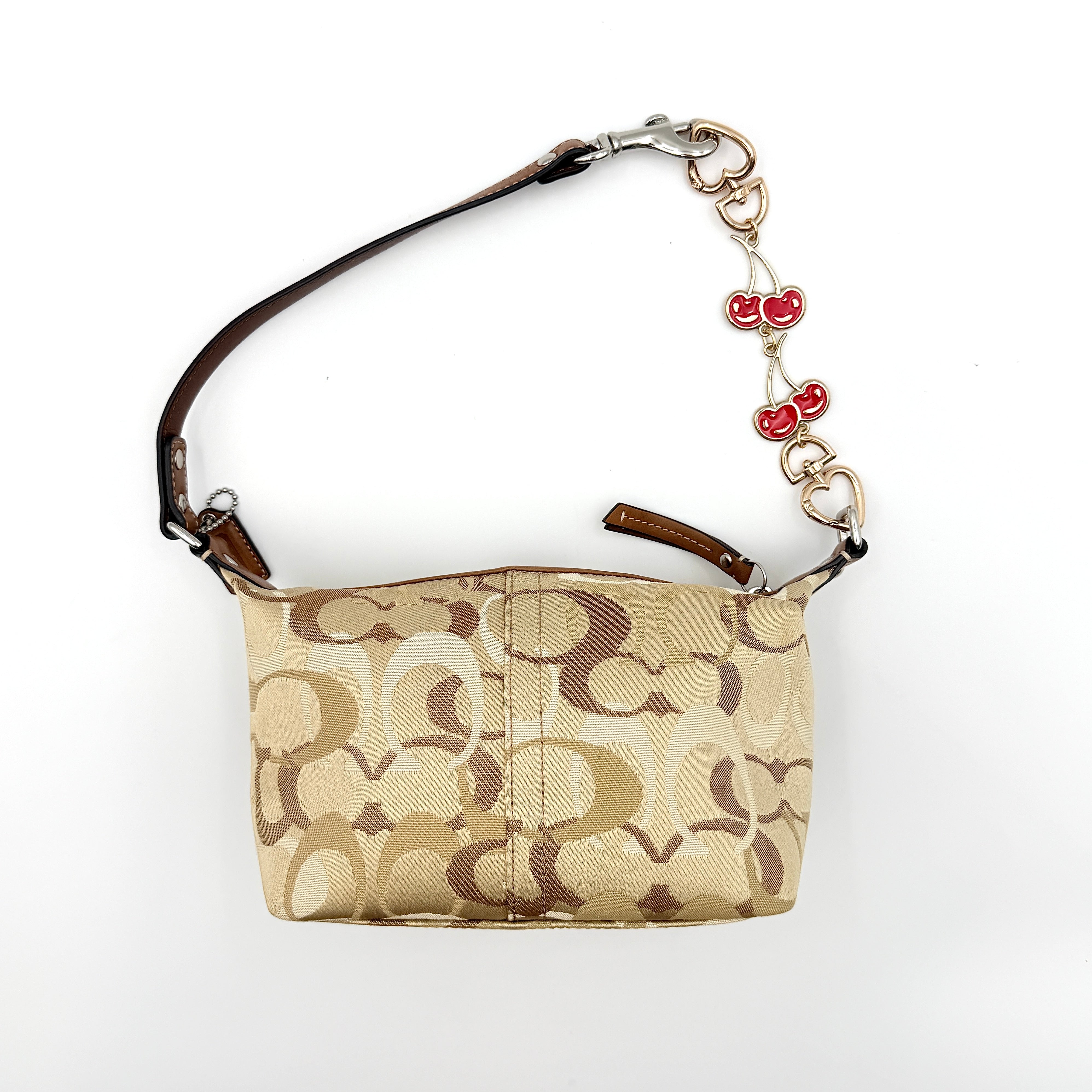 Coach Signature Stripe Mini Hobo Shoulder Bag in brown canvas with white and caramel stripes, featuring a brown leather strap and playful cherry charms.