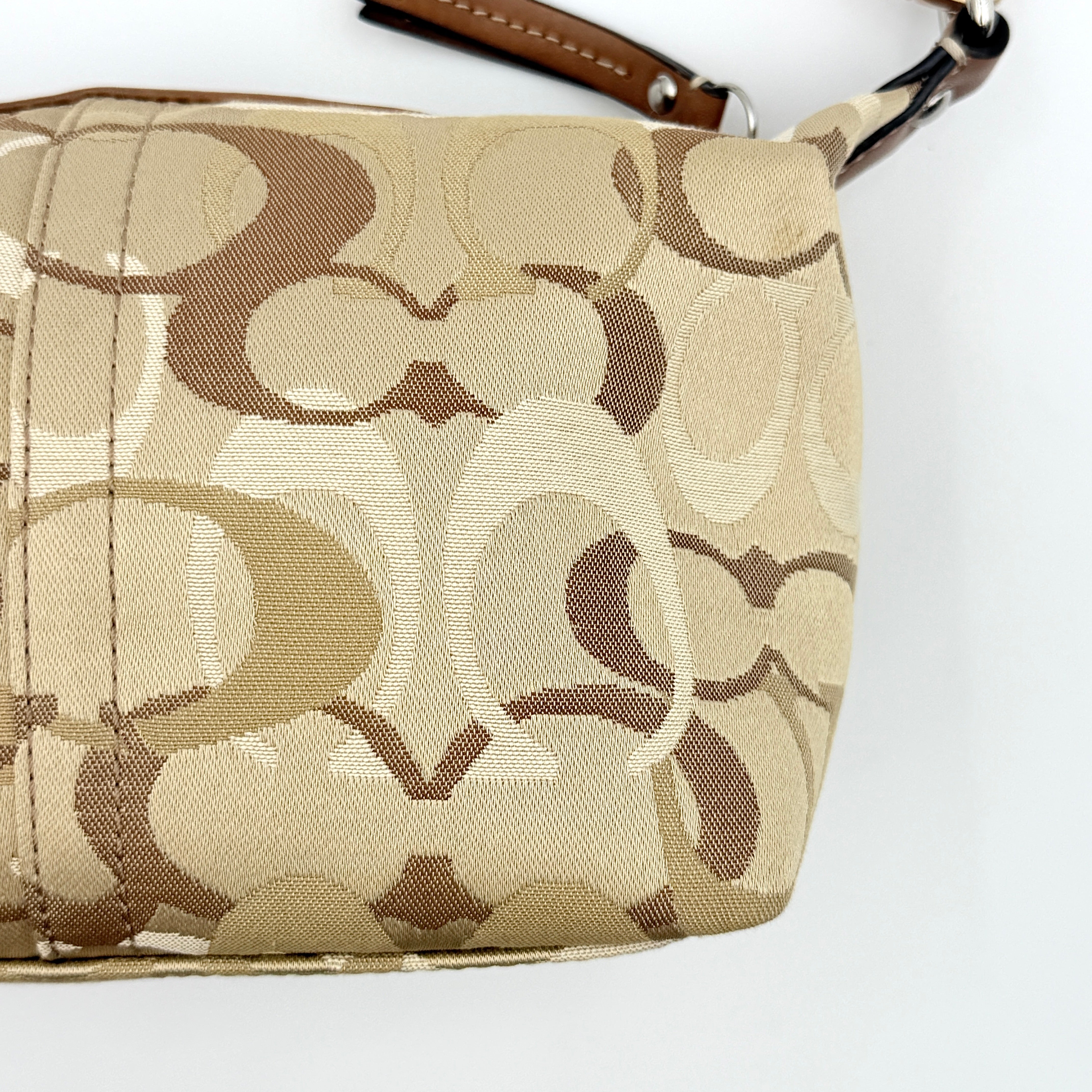 Coach Signature Stripe Mini Hobo Shoulder Bag in brown canvas with white and caramel stripes, featuring a brown leather strap and playful cherry charms.
