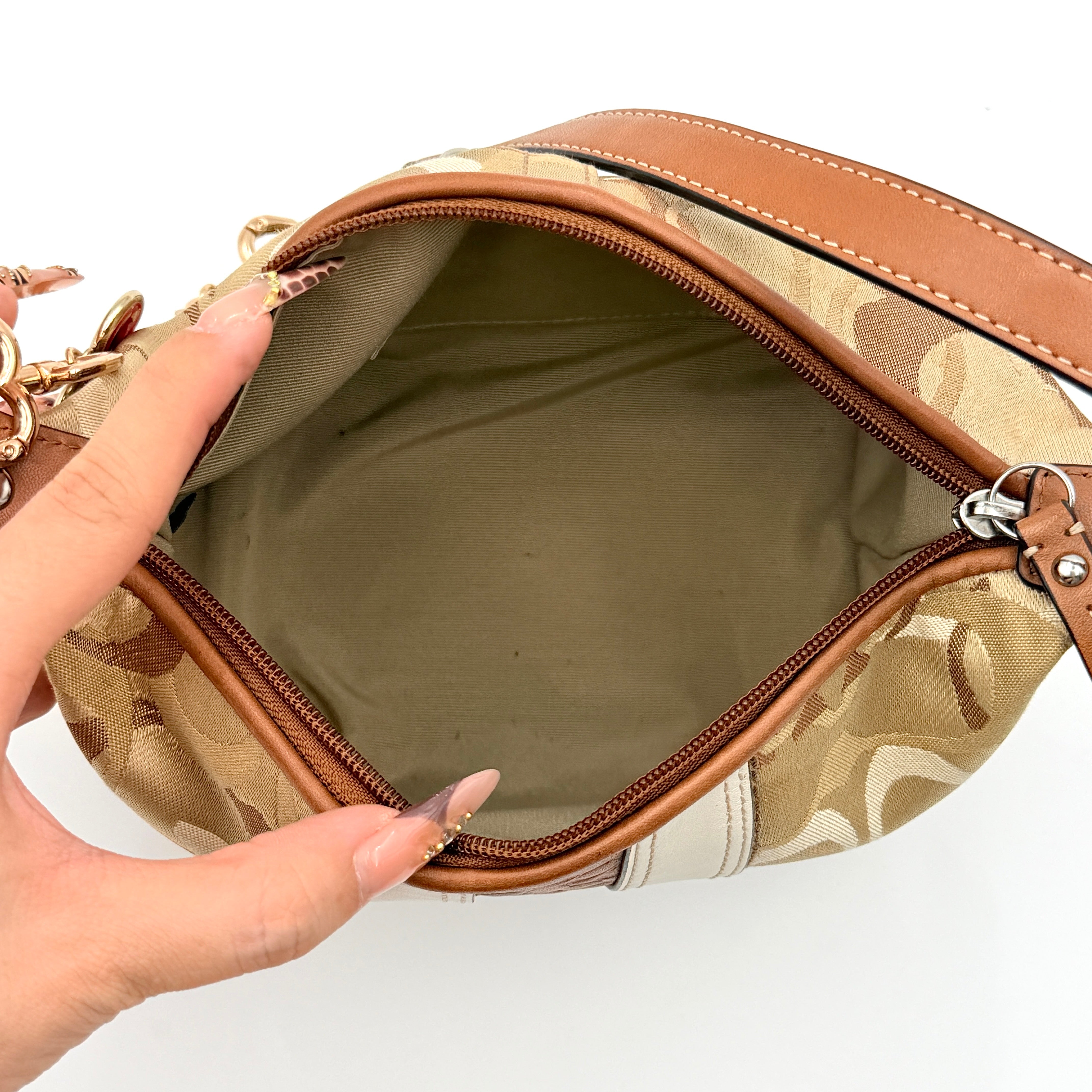 Coach Signature Stripe Mini Hobo Shoulder Bag in brown canvas with white and caramel stripes, featuring a brown leather strap and playful cherry charms.