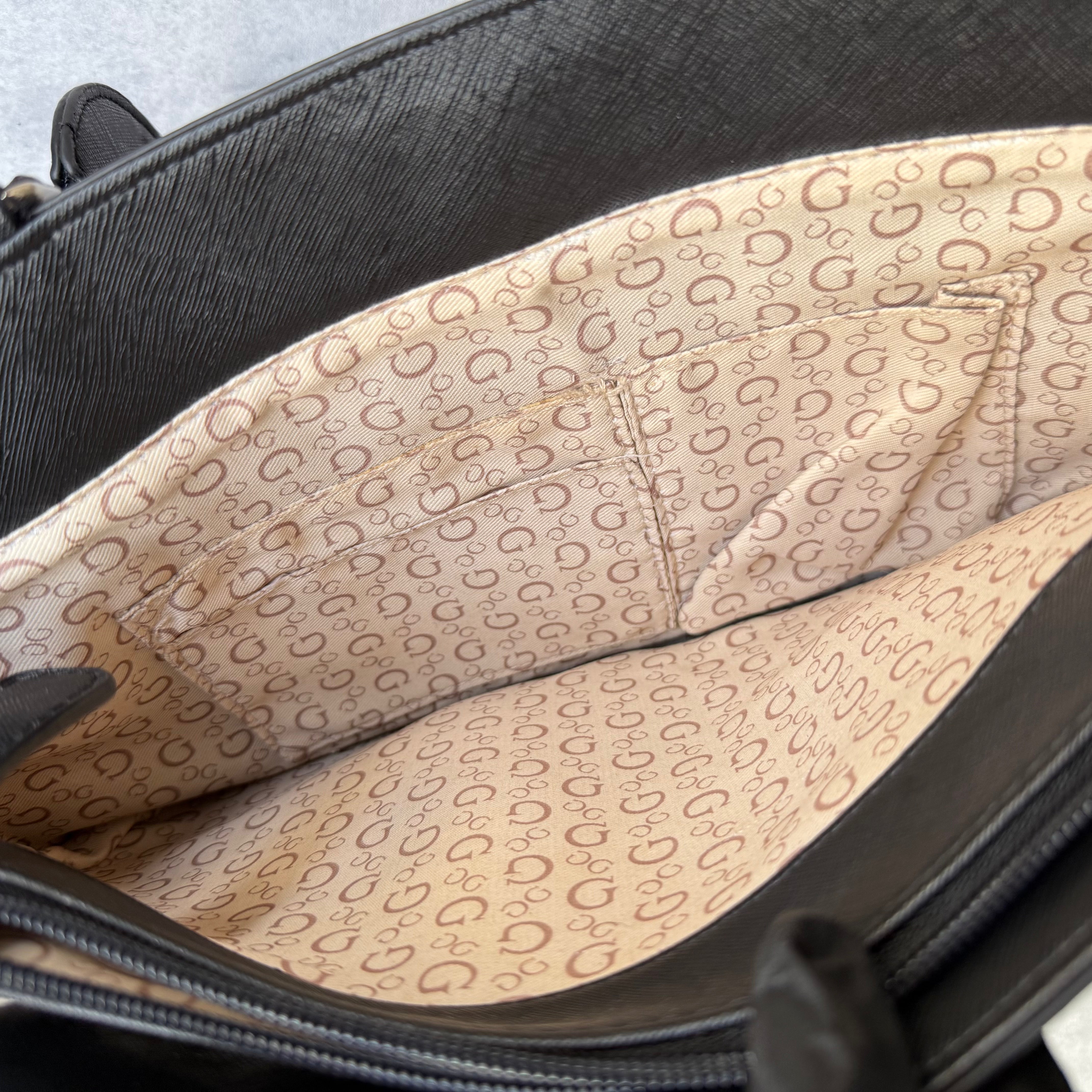 Guess Monogram Print Carryall Tote Bag in glossy black with logo charm and beige interior lining