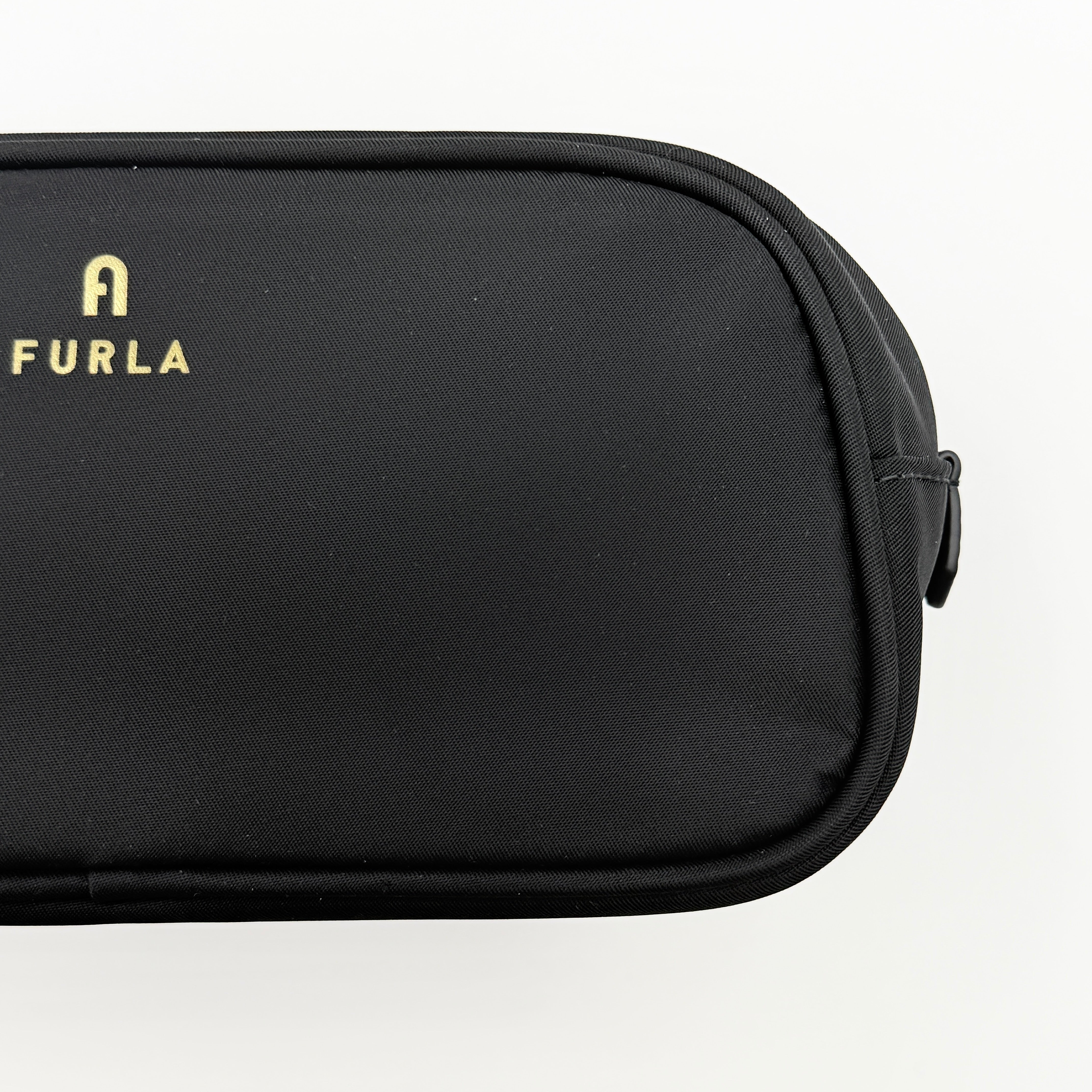 Furla Camelia Cosmetic Case in black nylon with gold logo and wristlet strap, shown with original tag.