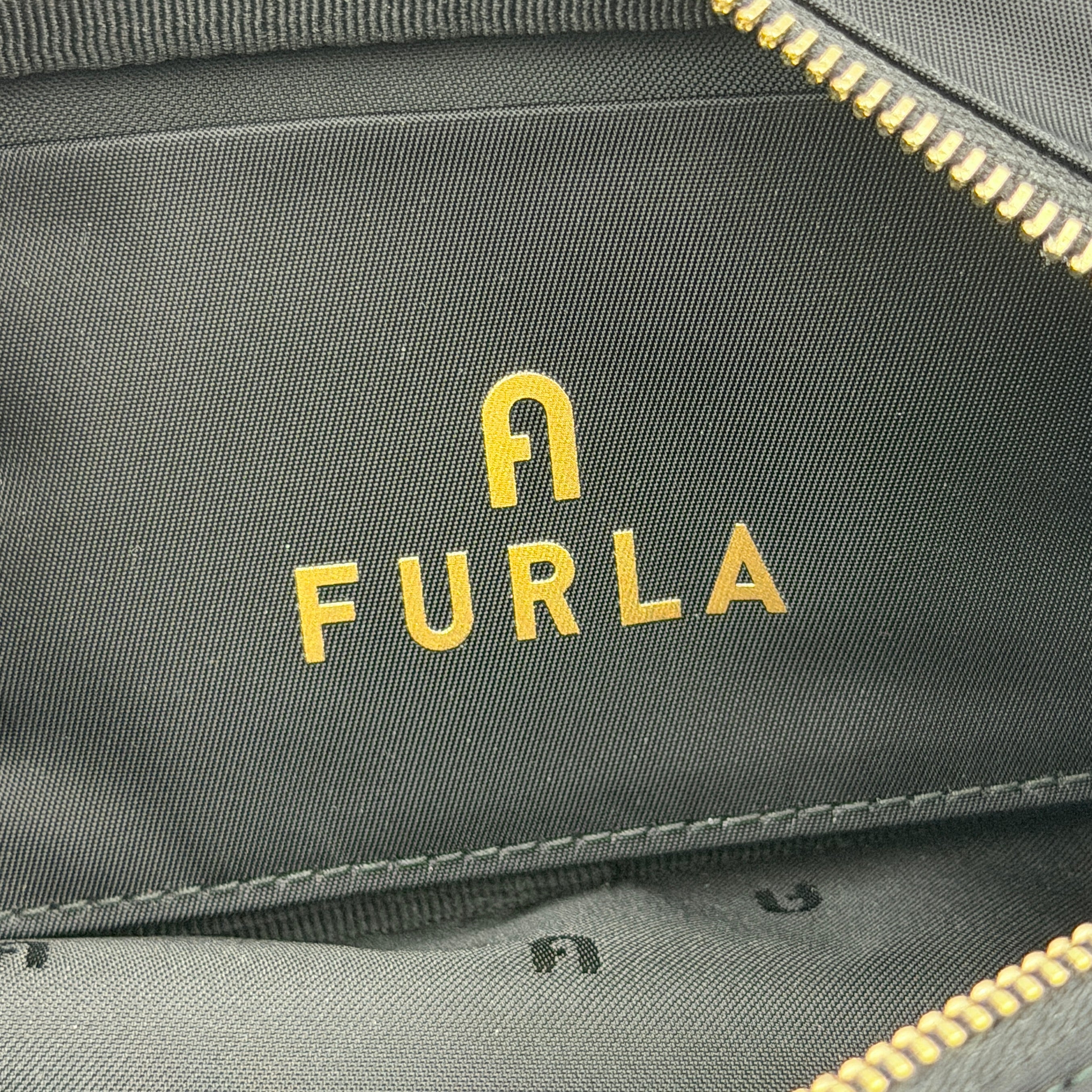 Furla Camelia Cosmetic Case in black nylon with gold logo and wristlet strap, shown with original tag.