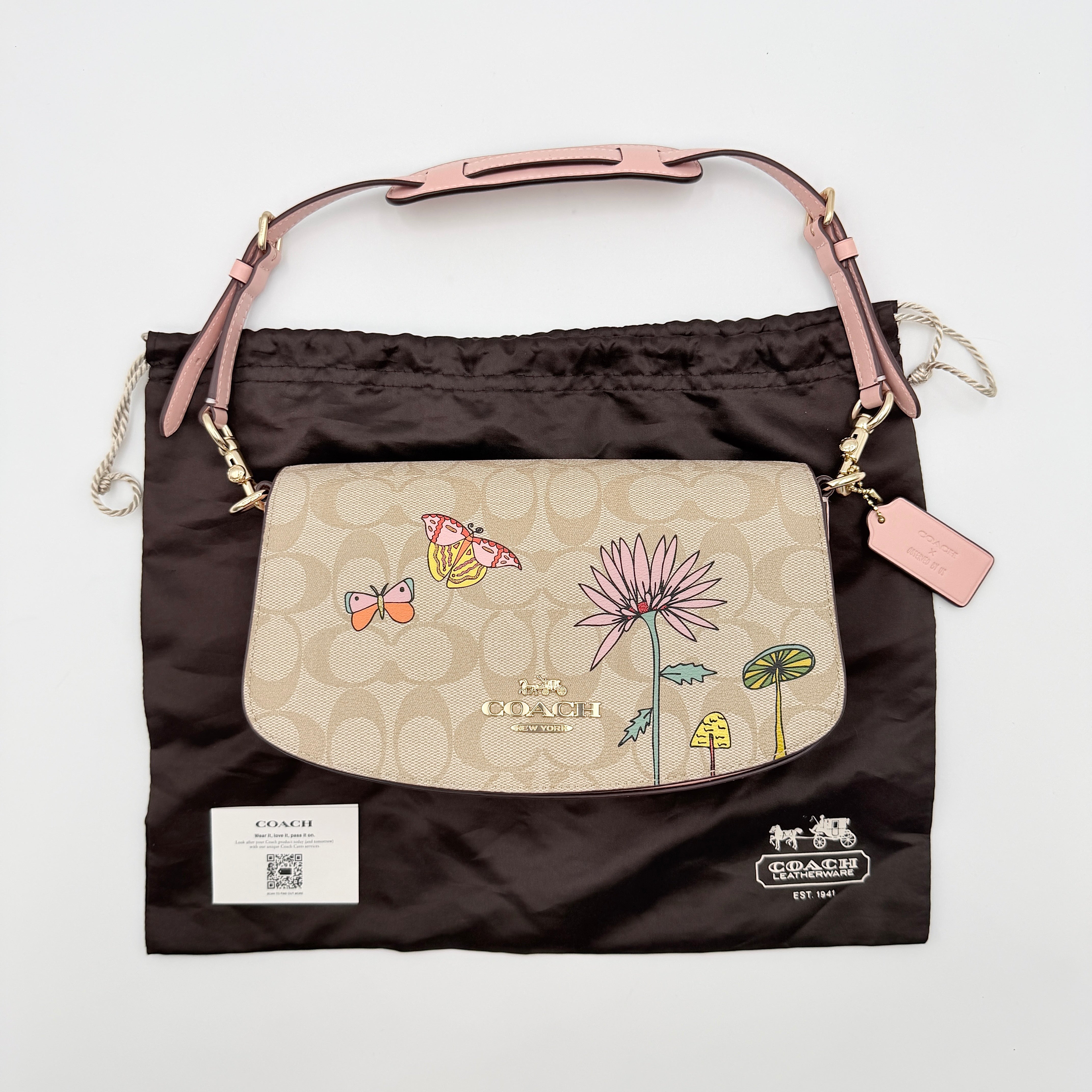 Coach X Observed By Us Andrea Shoulder Bag in beige monogram canvas with pink illustrations and pink leather strap.