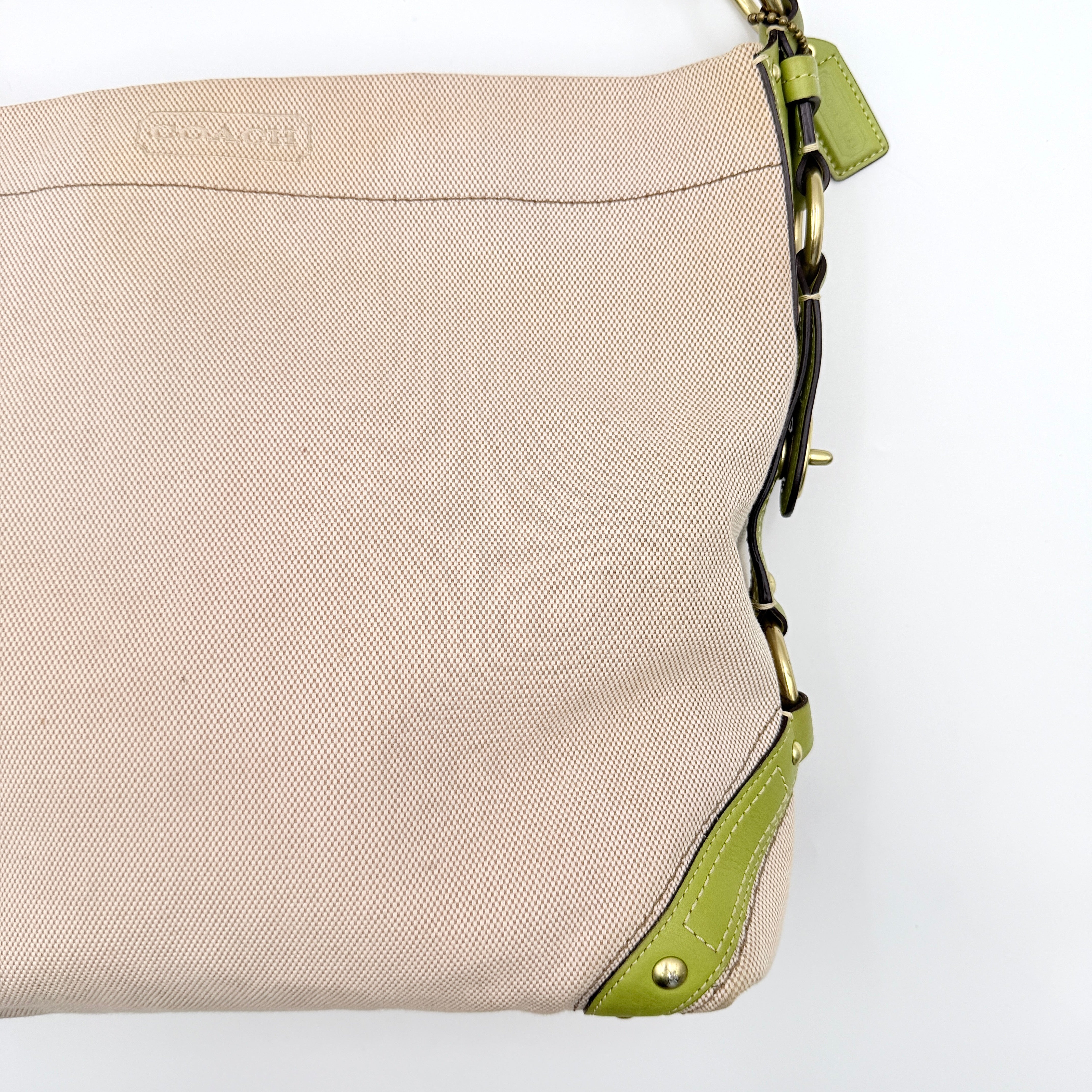 Coach Carly Hobo Shoulder Bag in beige canvas with green leather trim and gold hardware, shown on a white background.
