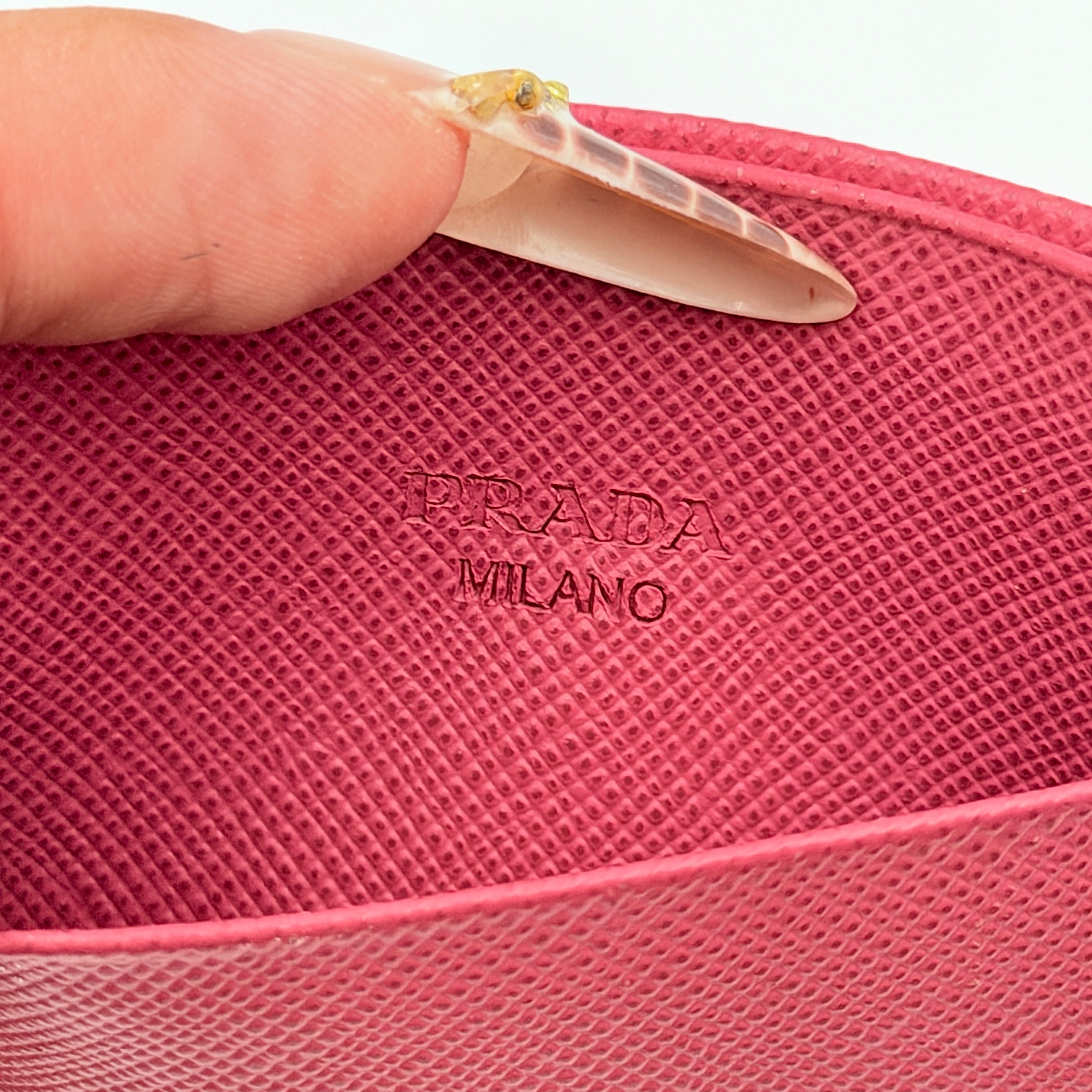 Prada Saffiano card holder in pink leather with gold-tone triangle logo plaque on the front.