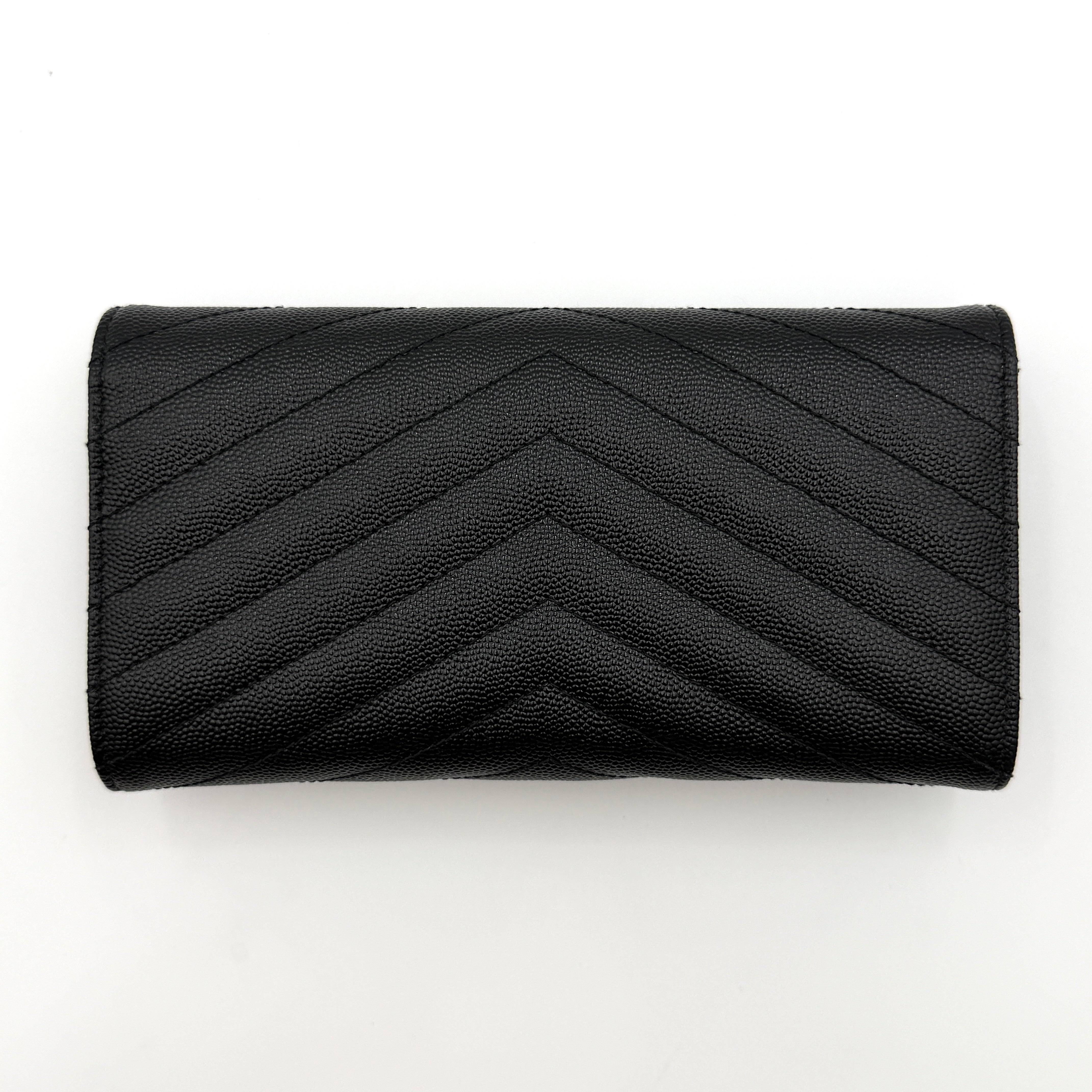 Saint Laurent Cassandre Large Flap Wallet in black grained leather with gold YSL monogram and chevron quilting.