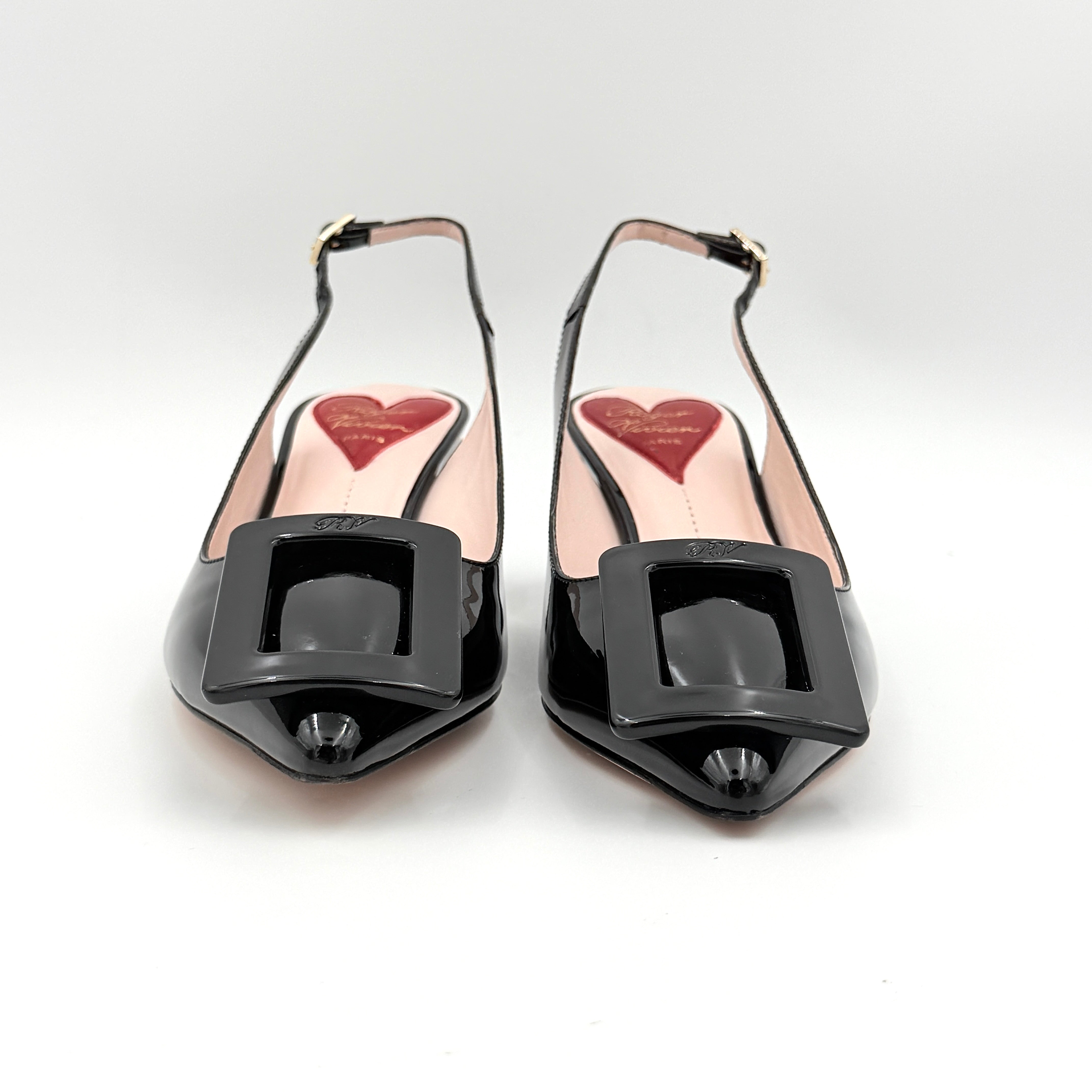 A pair of Roger Vivier Virgule black patent slingback pumps featuring a sculpted heel and oversized buckle at the toe.