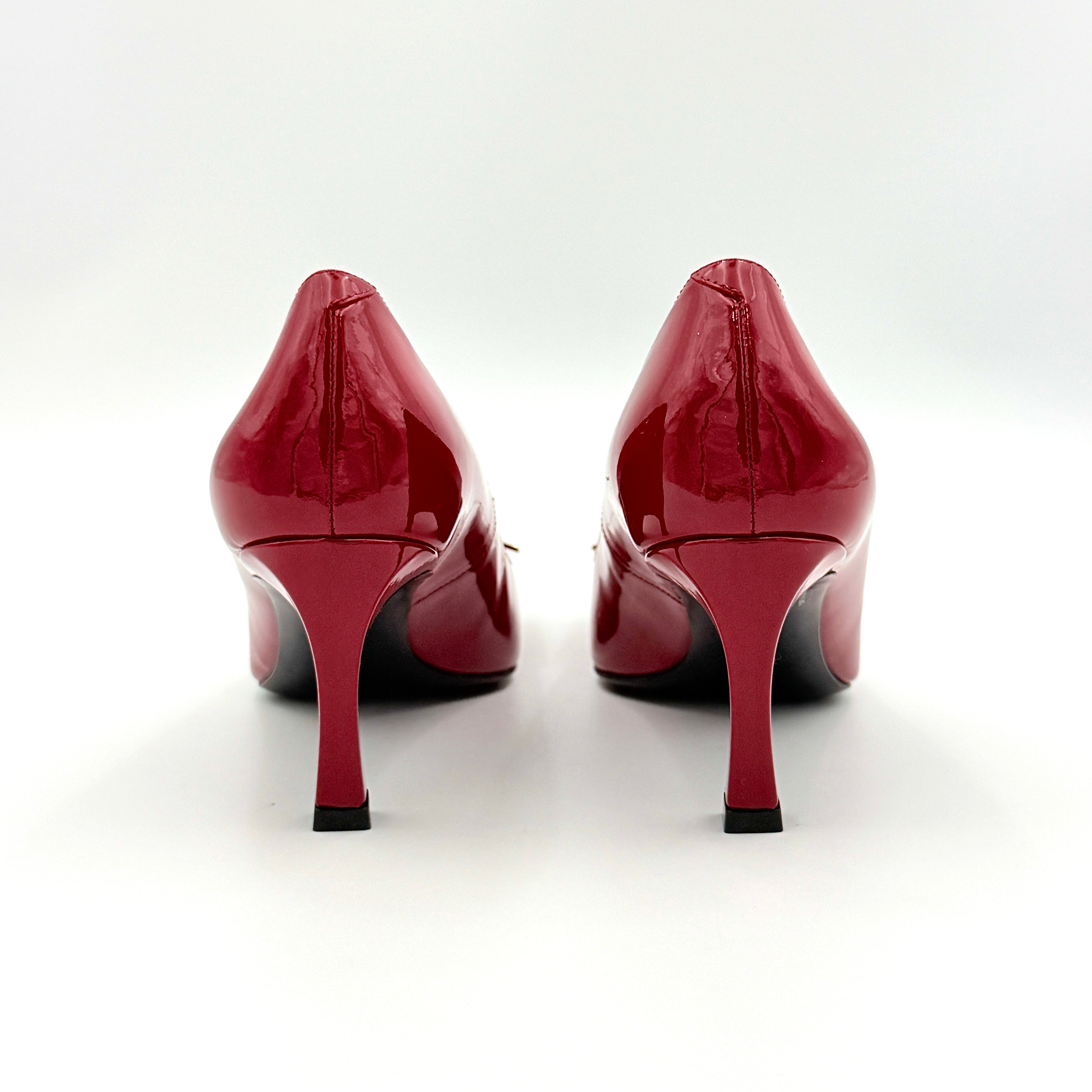 Pair of Roger Vivier Belle Vivier Trompette patent pumps in glossy red with gold-tone buckles, exuding a polished finish.