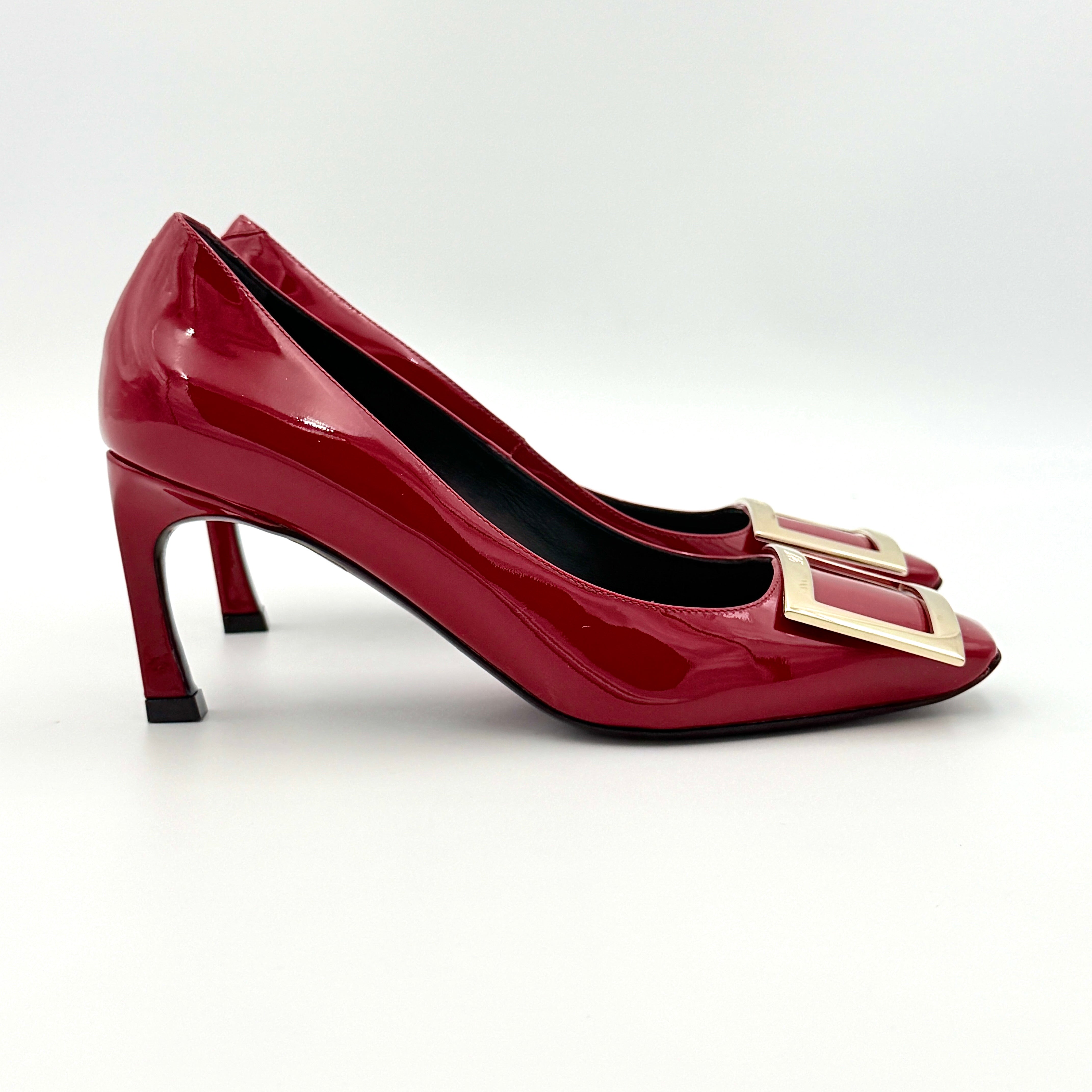 Pair of Roger Vivier Belle Vivier Trompette patent pumps in glossy red with gold-tone buckles, exuding a polished finish.