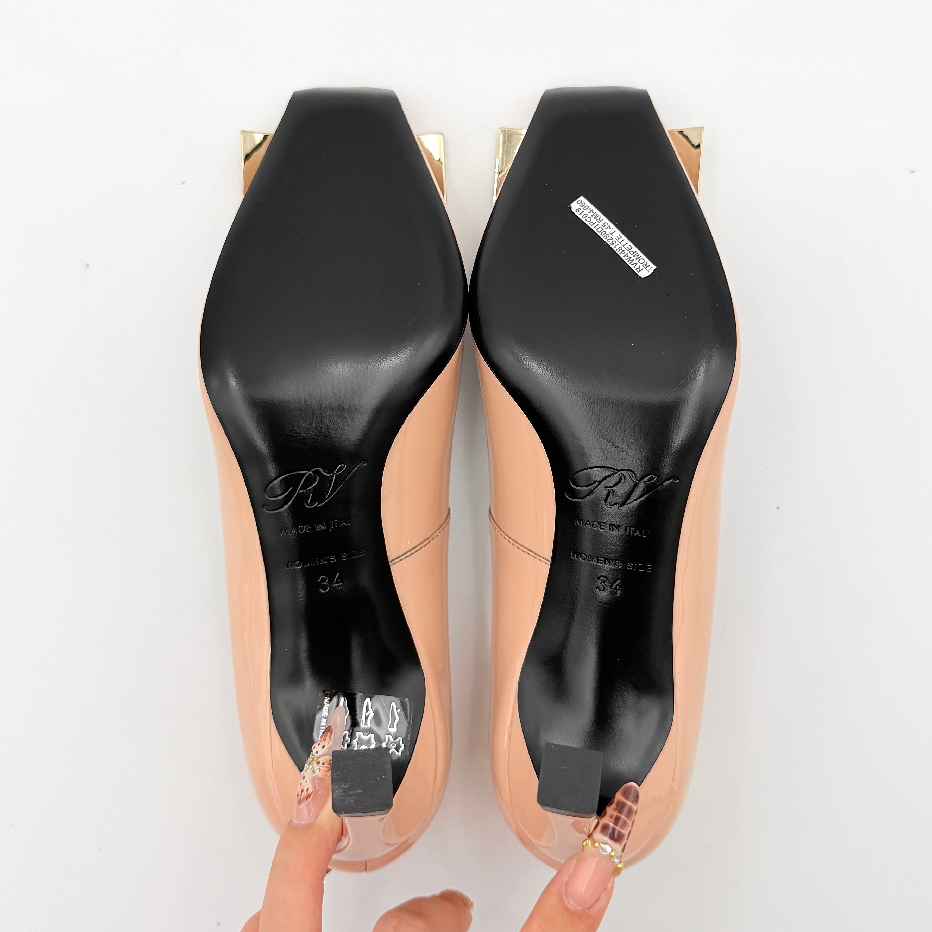 A pair of Roger Vivier Belle Vivier Trompette pumps in patent blush pink leather with signature gold buckles at the toe.