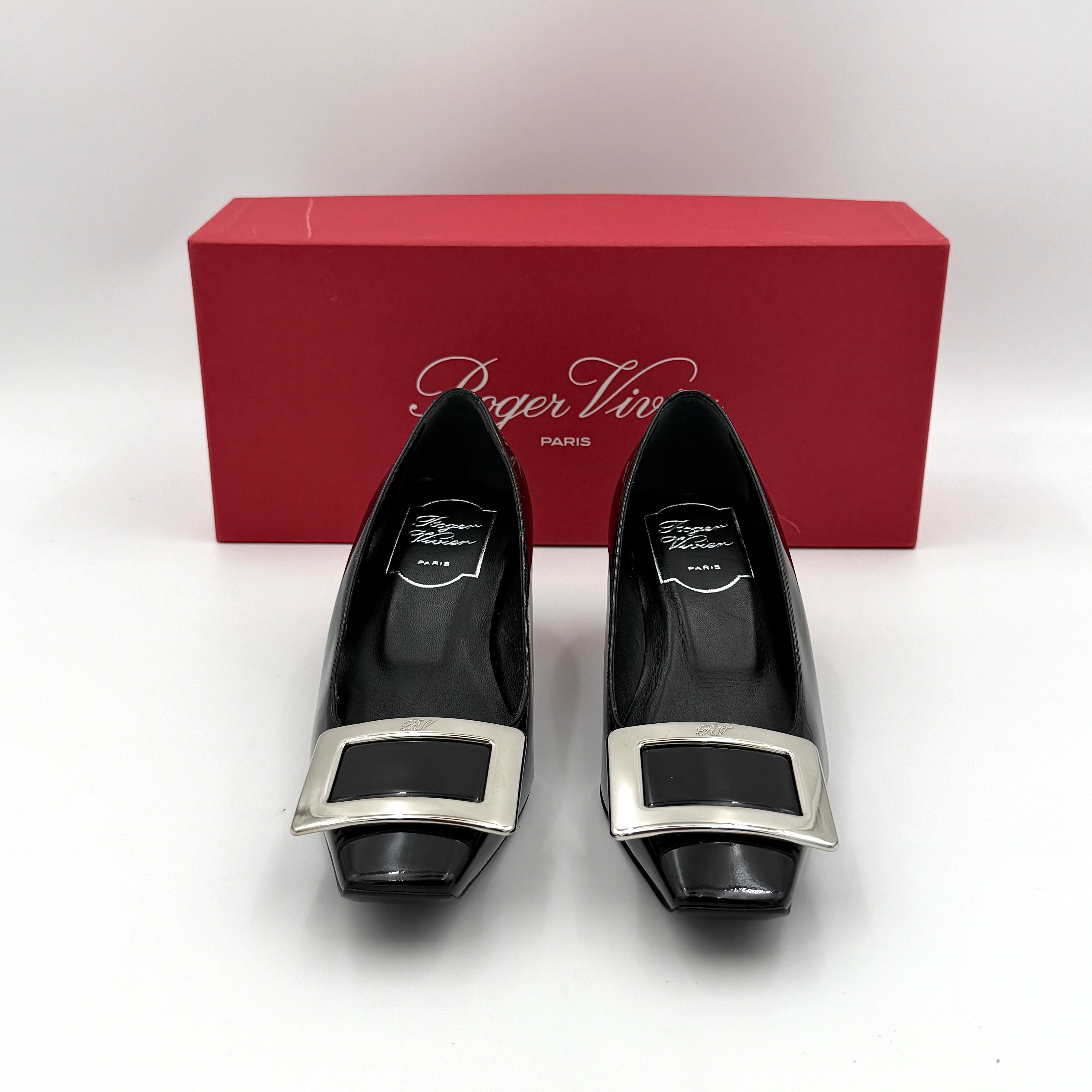 A pair of Roger Vivier Belle Vivier black patent pumps with signature silver-tone buckles, displayed at an angle.