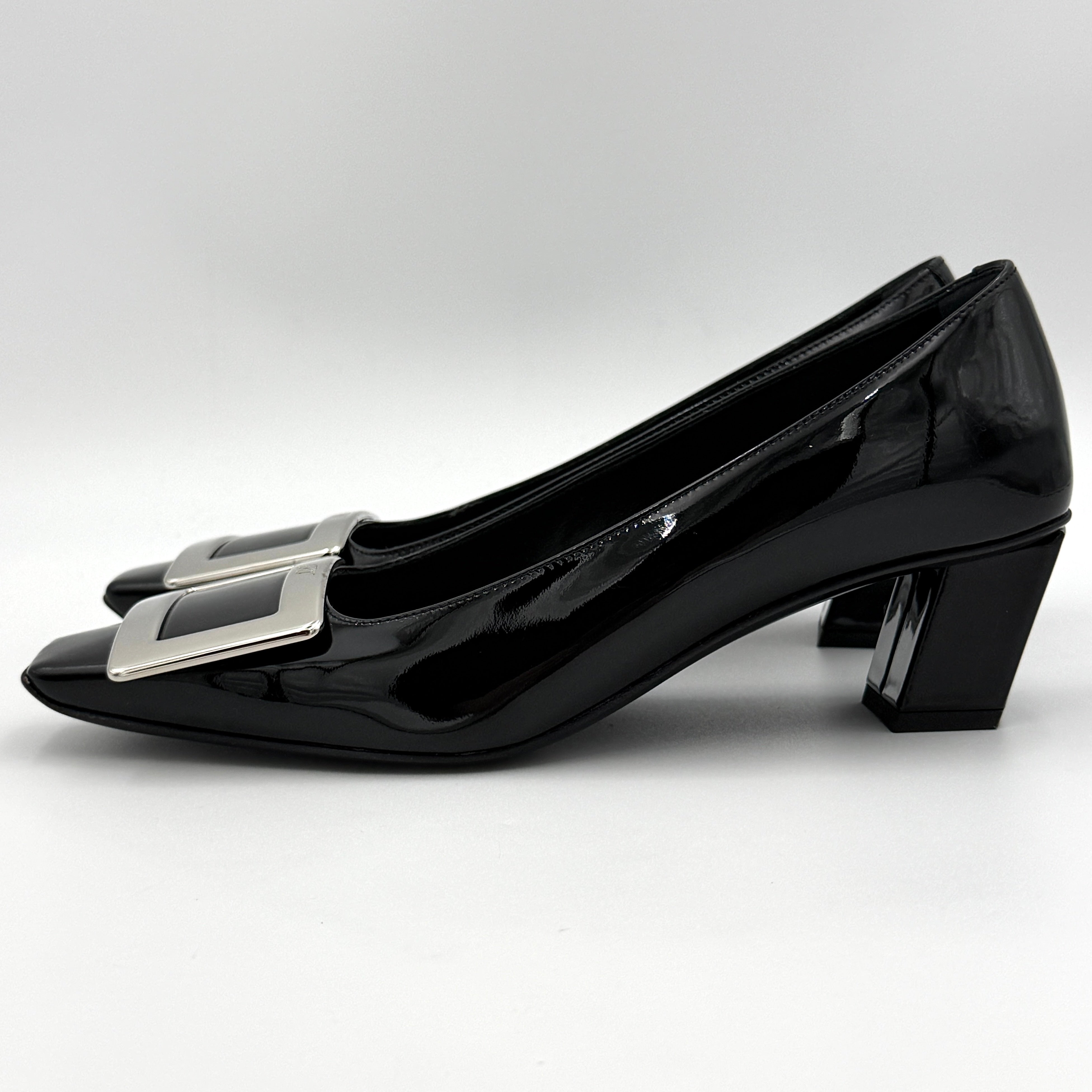 A pair of Roger Vivier Belle Vivier black patent pumps with signature silver-tone buckles, displayed at an angle.