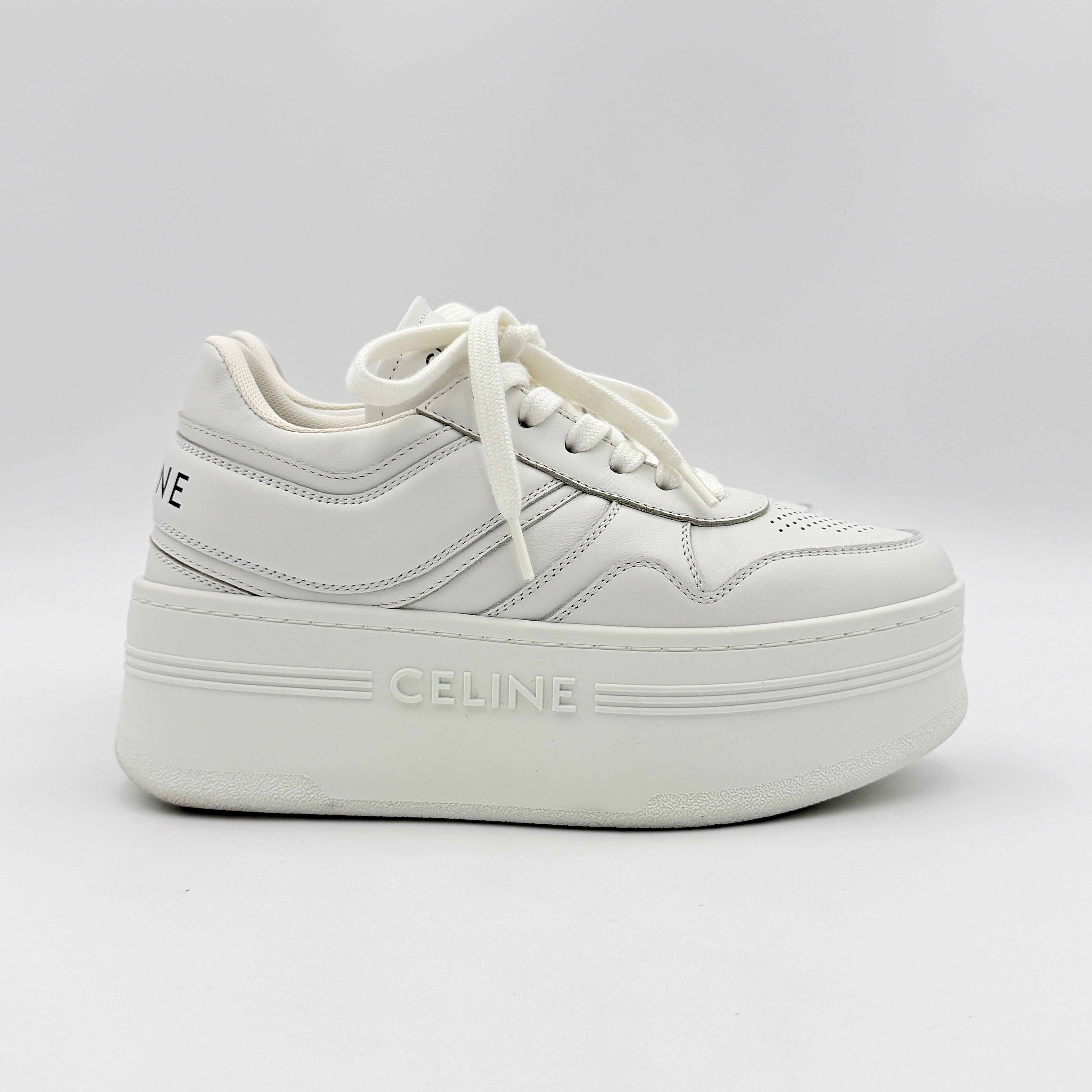 Celine white leather block platform sneakers with bold embossed sole and lace-up front, displayed at a slight angle.
