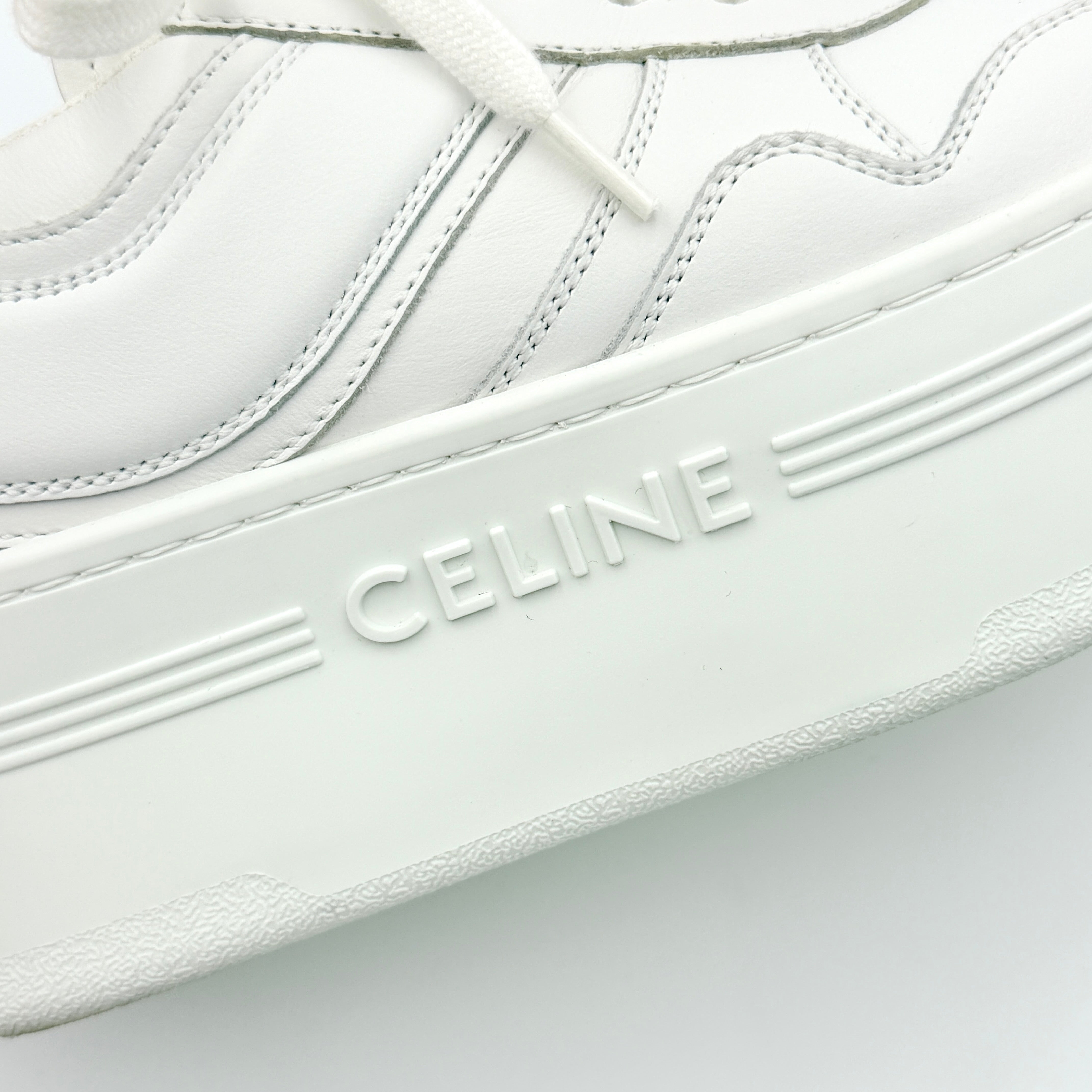 Celine white leather block platform sneakers with bold embossed sole and lace-up front, displayed at a slight angle.