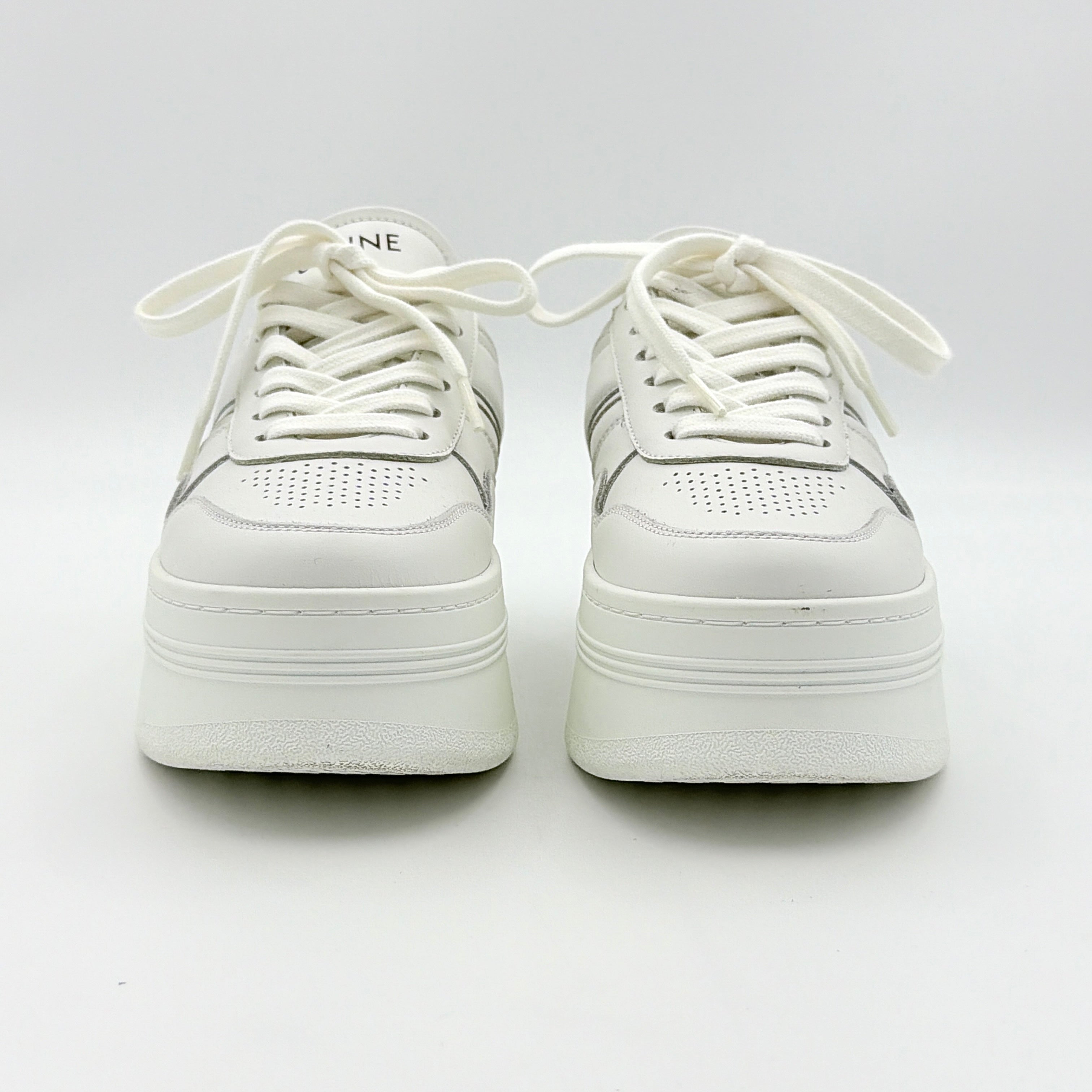 Celine white leather block platform sneakers with bold embossed sole and lace-up front, displayed at a slight angle.