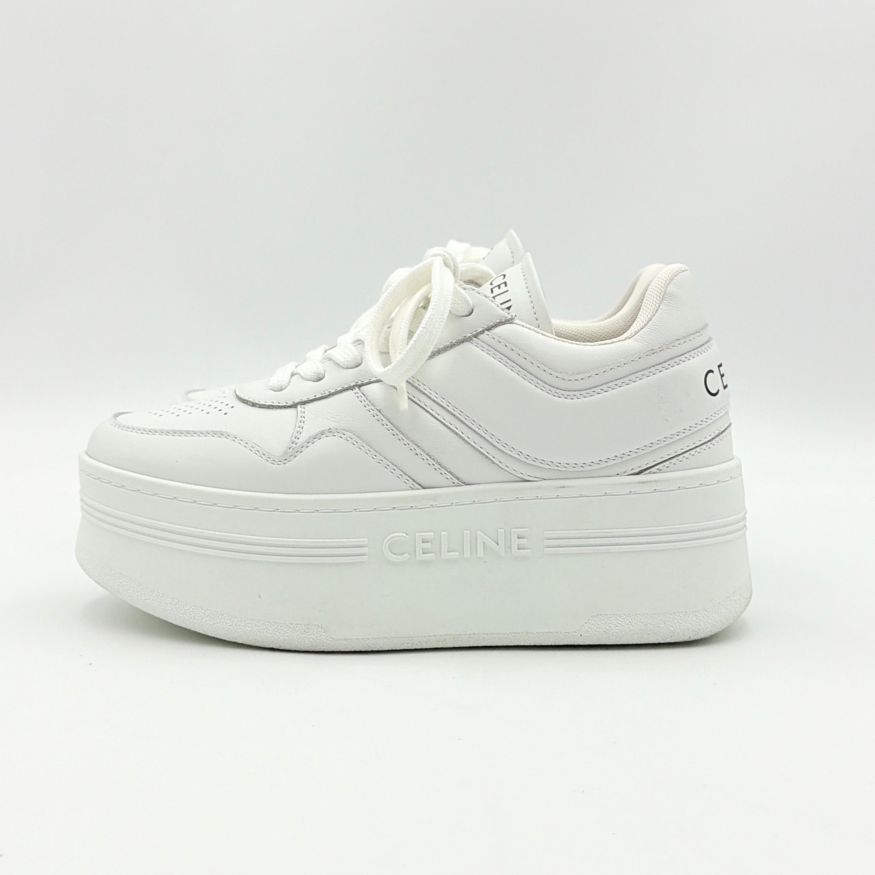 Celine white leather block platform sneakers with bold embossed sole and lace-up front, displayed at a slight angle.